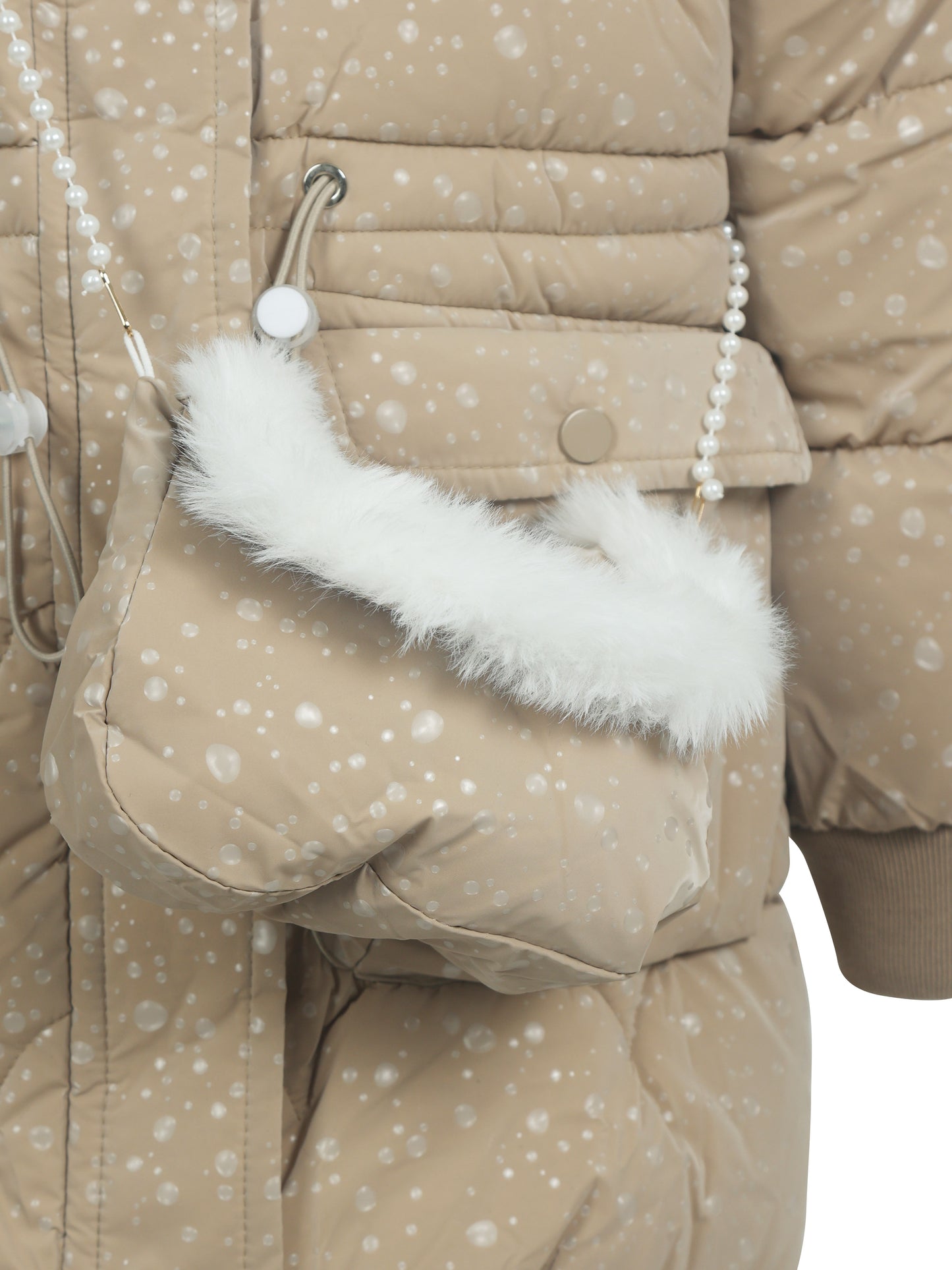 Close-up of a beige winter puffer jacket with white polka dot pattern, featuring a matching small crossbody bag with white faux fur trim and pearl strap detail.