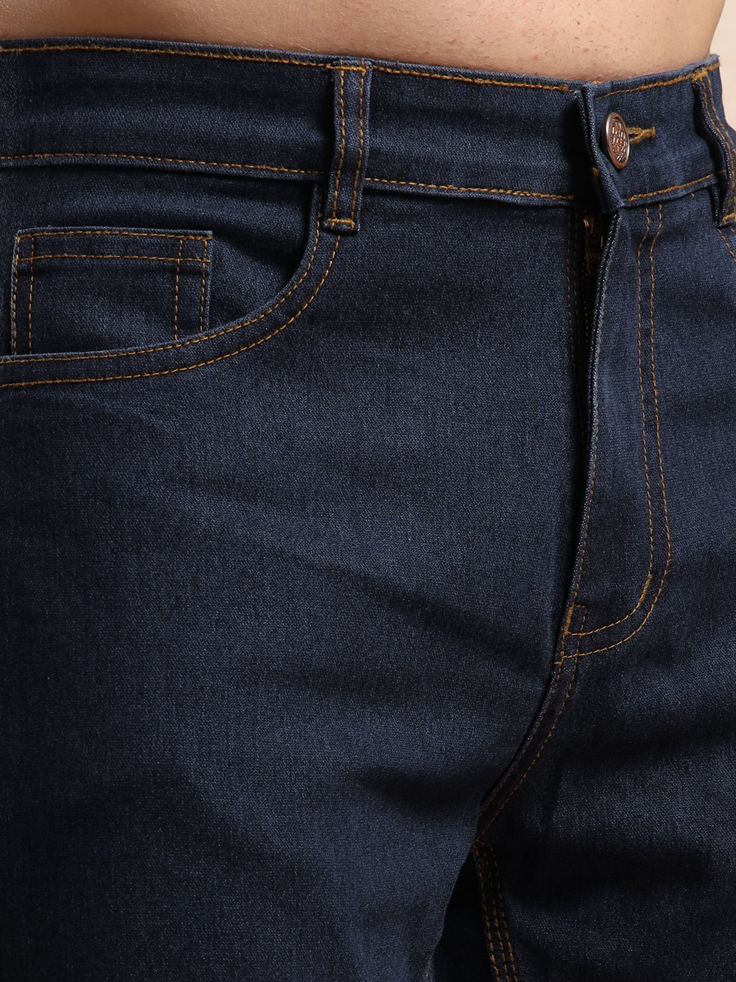 Close-up of waistband and pocket design on men’s slim fit jeans