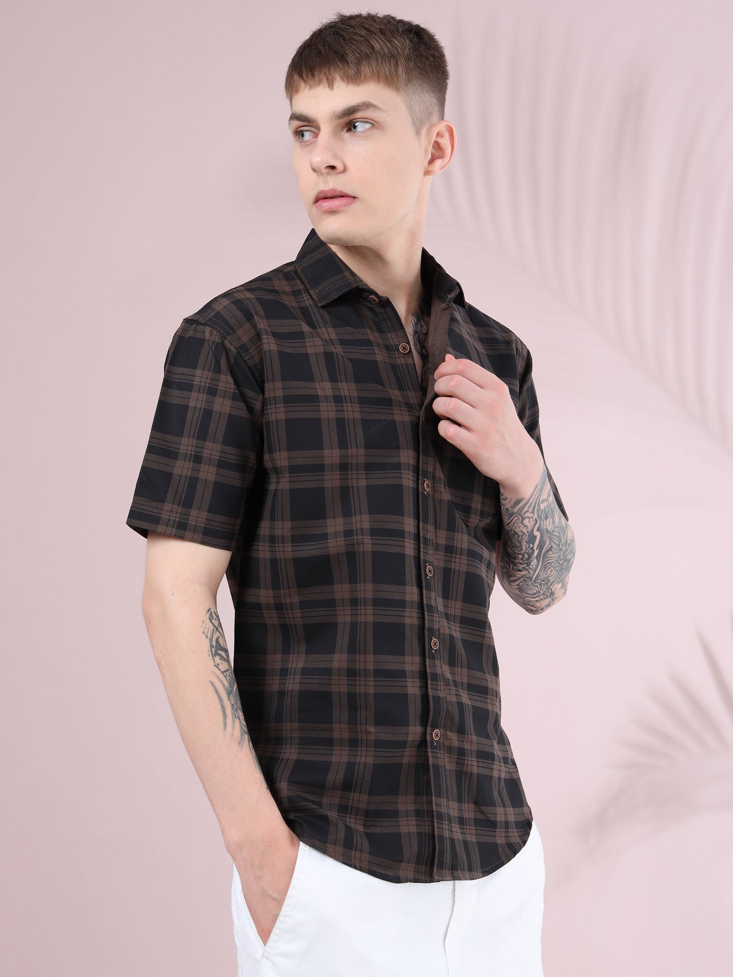 Men’s brown and black checked cotton short sleeve shirt paired with white pants.
