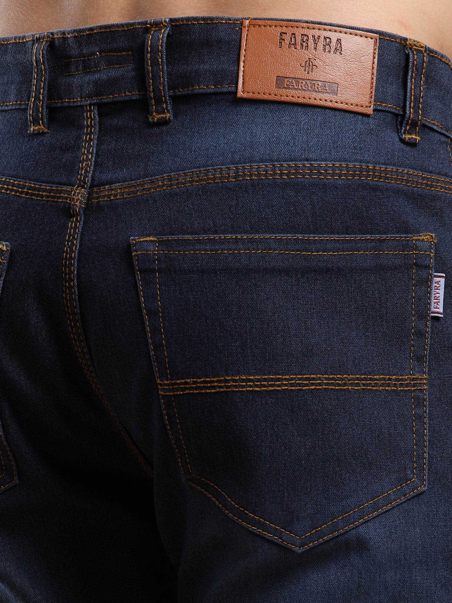 Back pocket design with Faryra leather patch branding on slim fit dark blue jeans