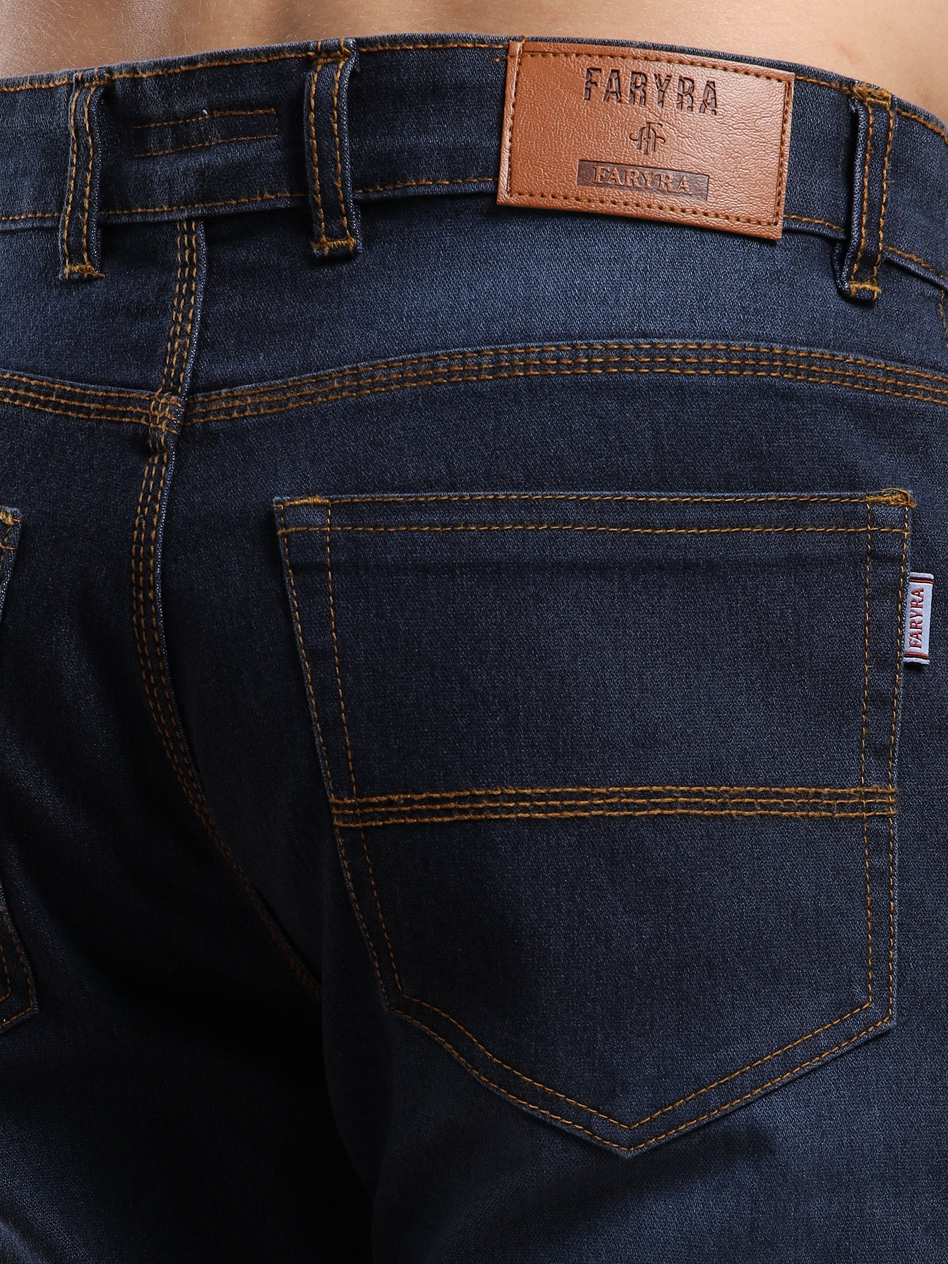 Back pocket design with Faryra leather patch branding on slim fit dark blue jeans