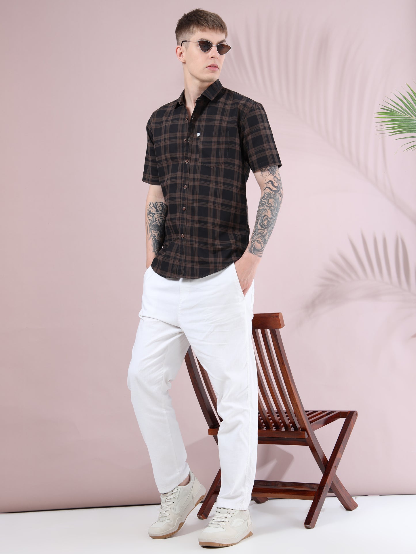 men’s brown & black checked short sleeve shirt styled with white trousers and sneakers for a casual modern look