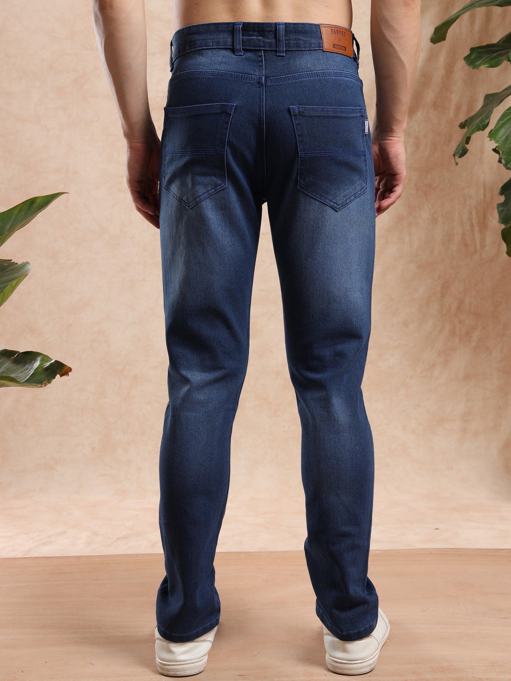 Back design of men’s slim fit jeans with patch pockets and leather branding tag