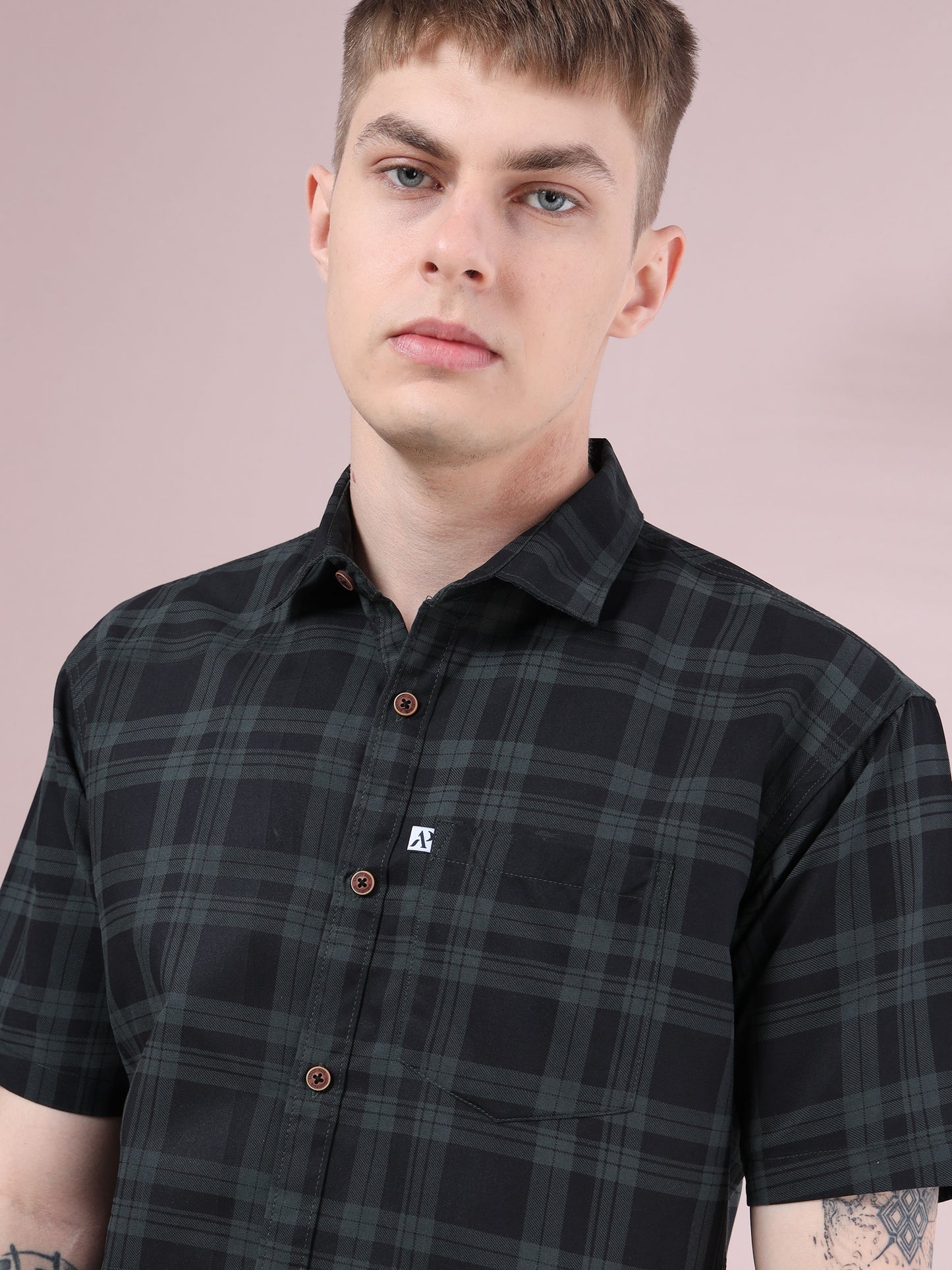 Model wearing black and green checkered short sleeve men’s shirt