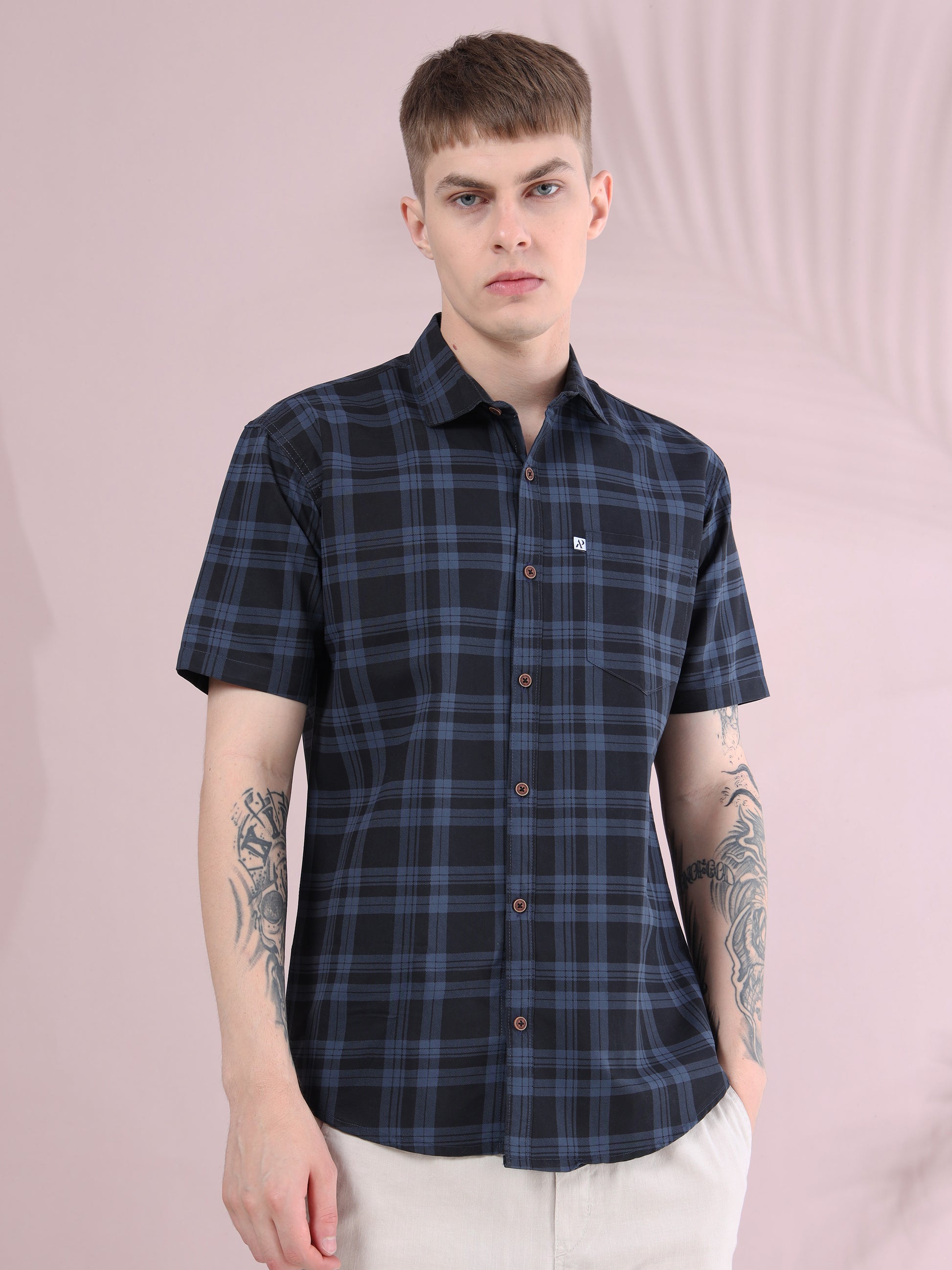 Front view of men’s ash grey & black checkered slim fit short sleeve shirt with beige trousers.
