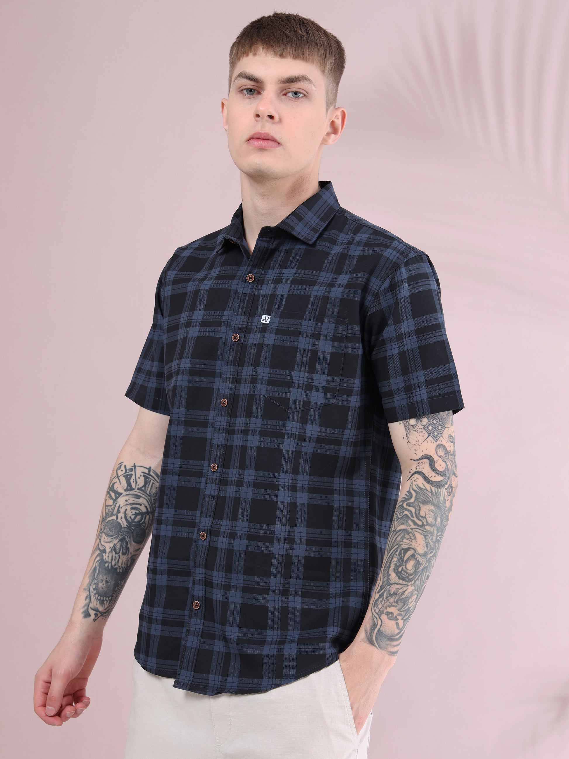 Men’s ash grey and black checked cotton short sleeve shirt paired with beige trousers.