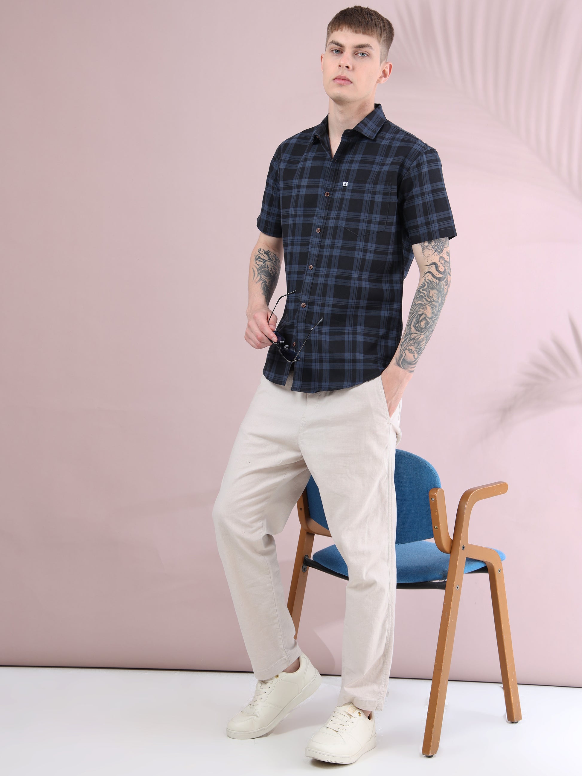 men’s ash grey & black checked short sleeve shirt styled with beige trousers and sneakers.