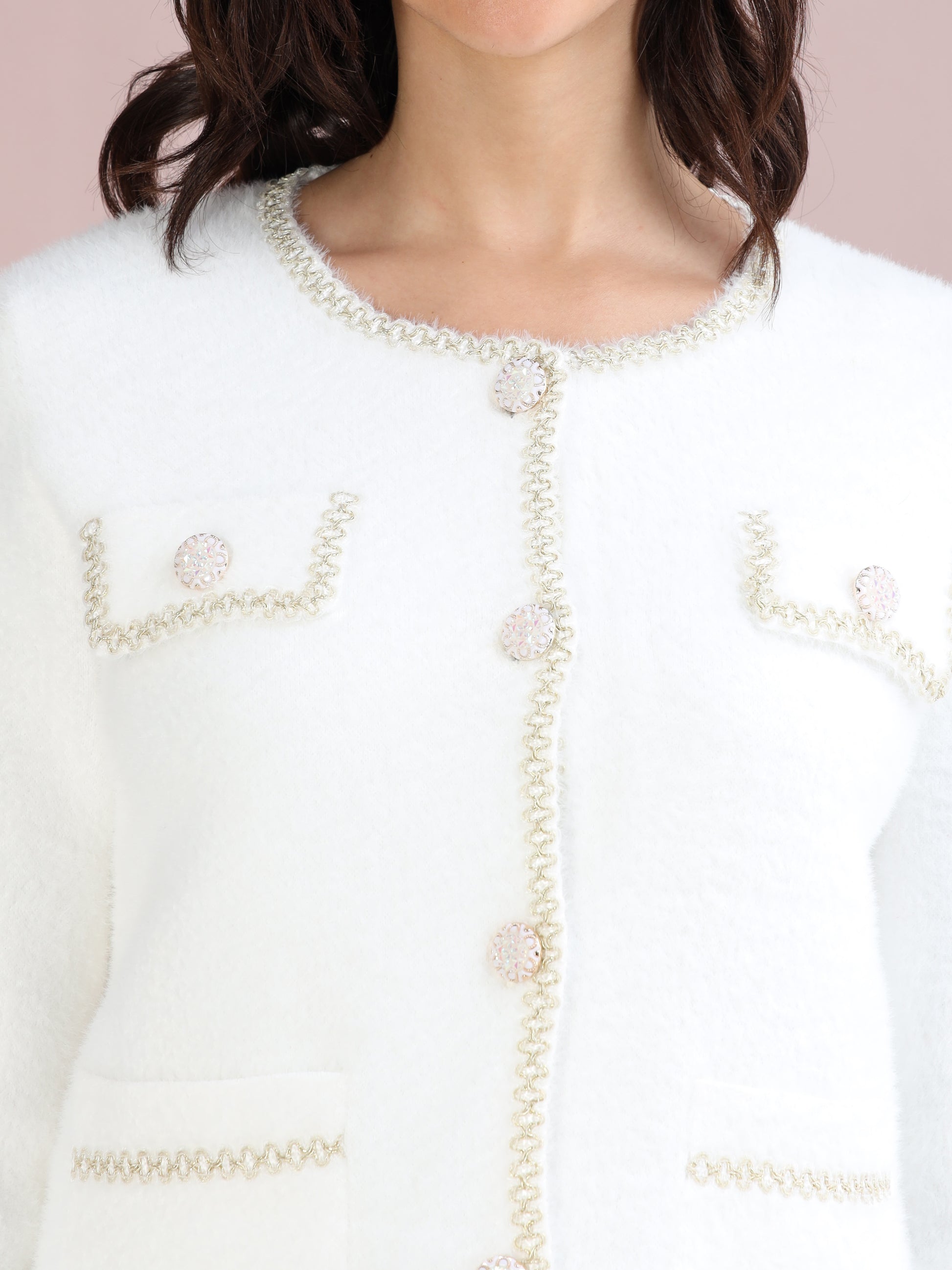 white cardigan sweater highlighting pearl button details and decorative edging