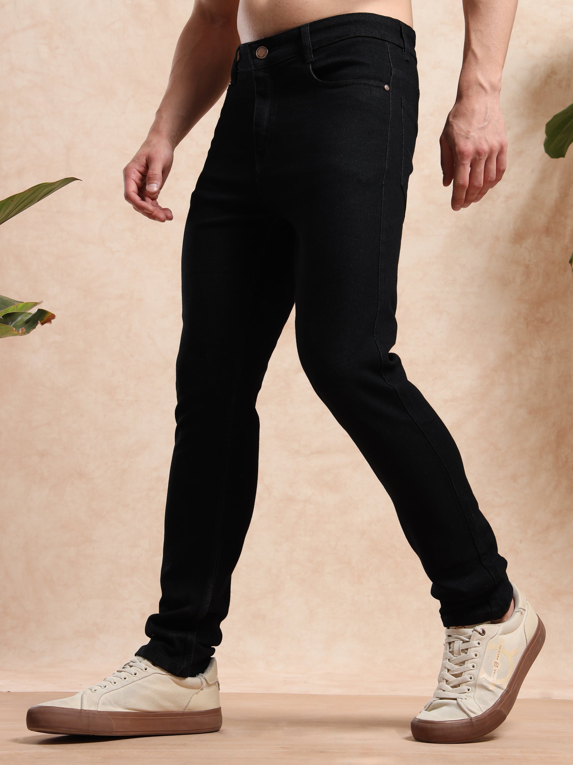 Side walking pose showcasing slim fit black denim for men