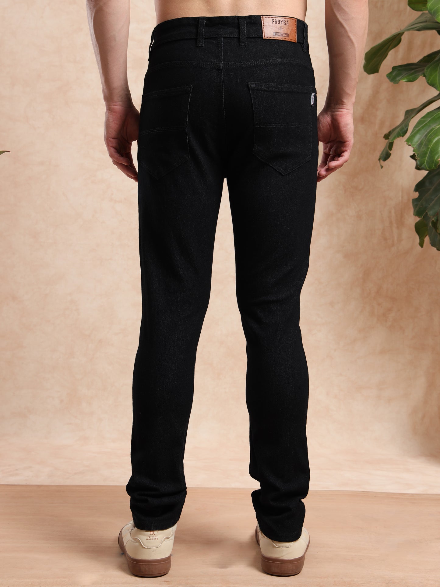 Back view of men's black slim fit jeans with Faryra leather brand patch