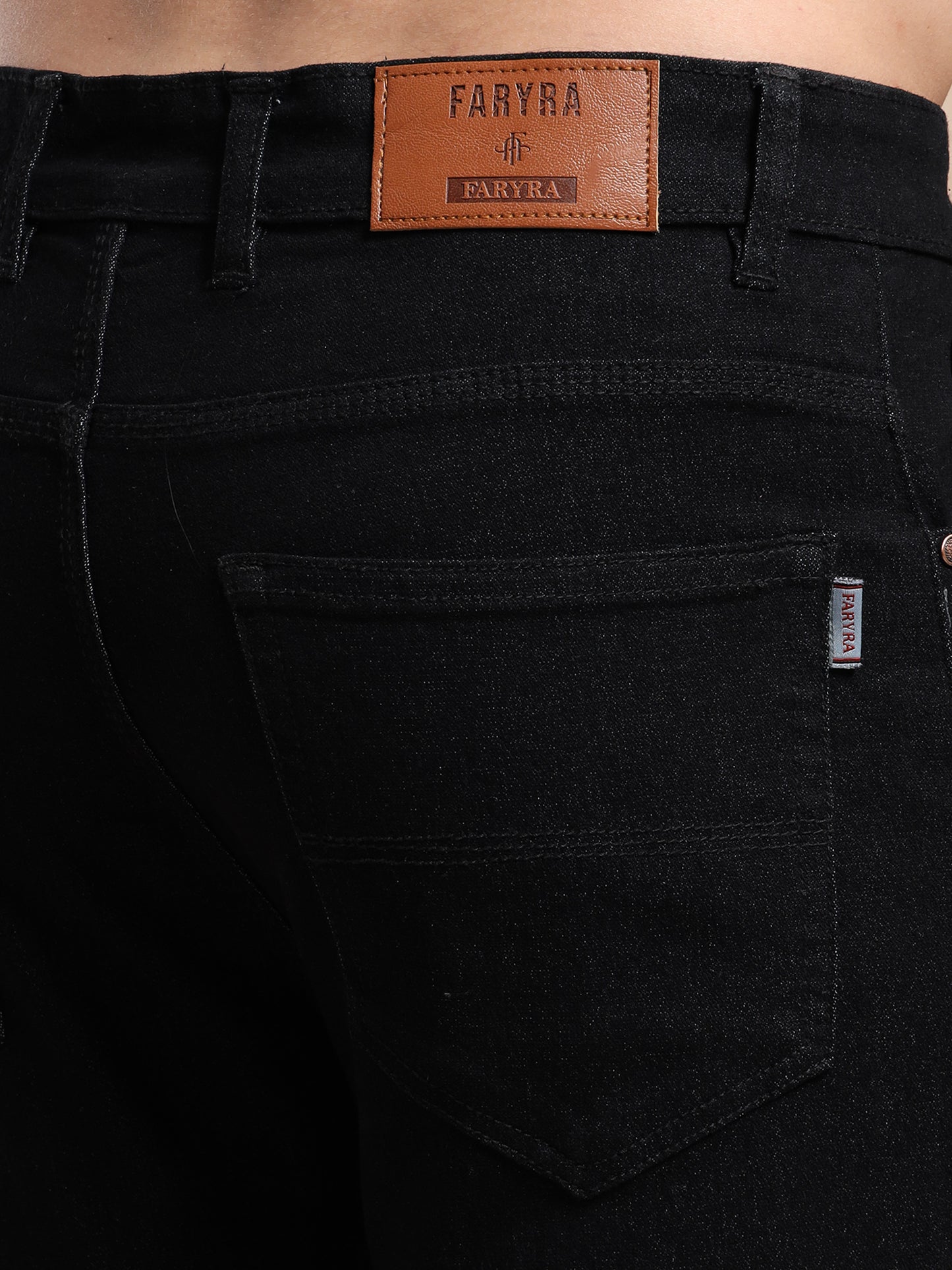 Back pocket and leather brand label detail on men's black jeans
