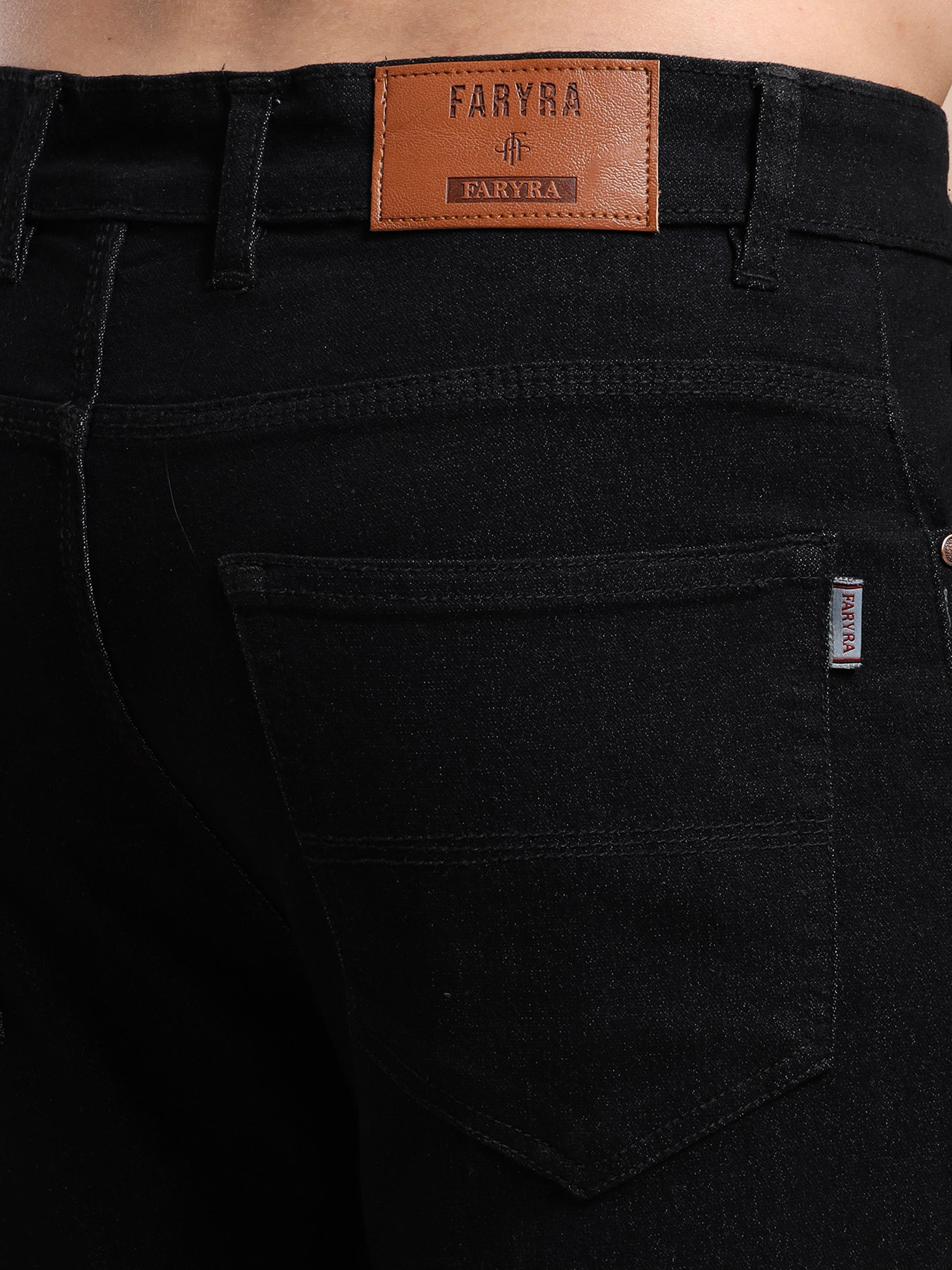 Back pocket and leather brand label detail on men's black jeans