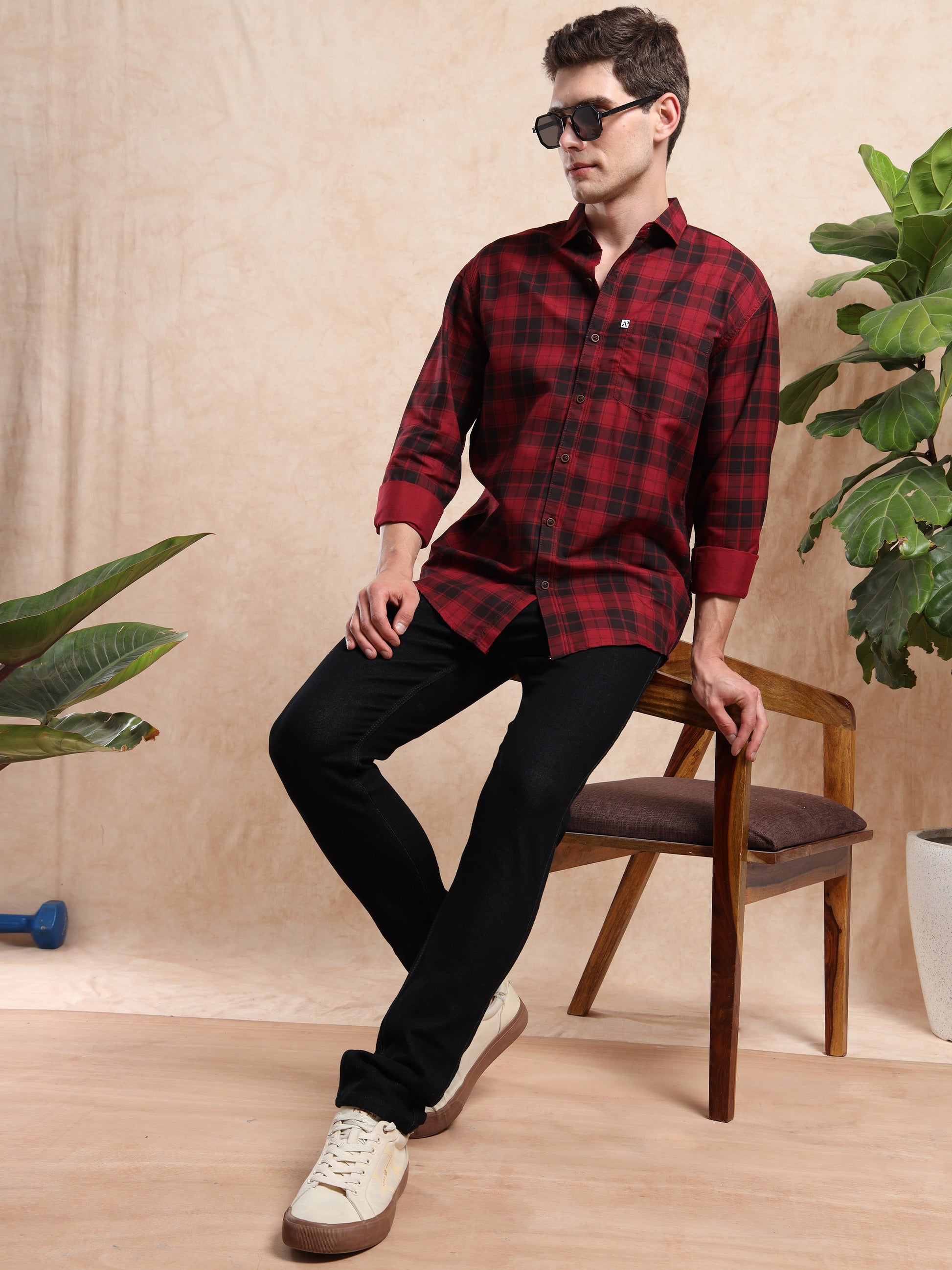 a black slim fit jeans paired with red checked shirt and sneakers