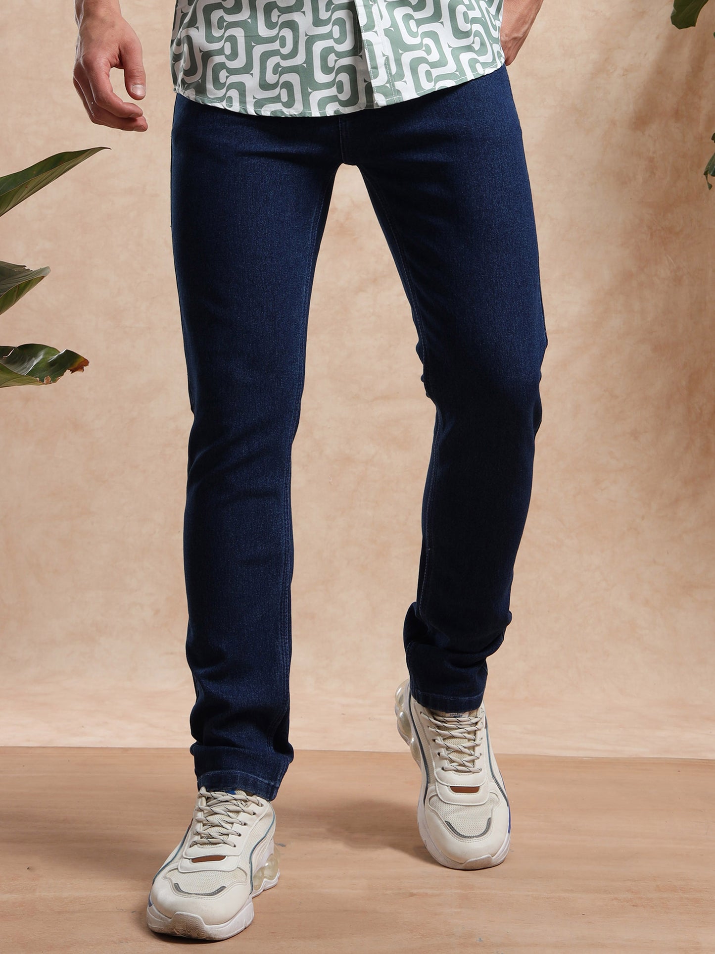 Men’s slim fit dark blue denim jeans styled with printed shirt and sneakers – casual wear