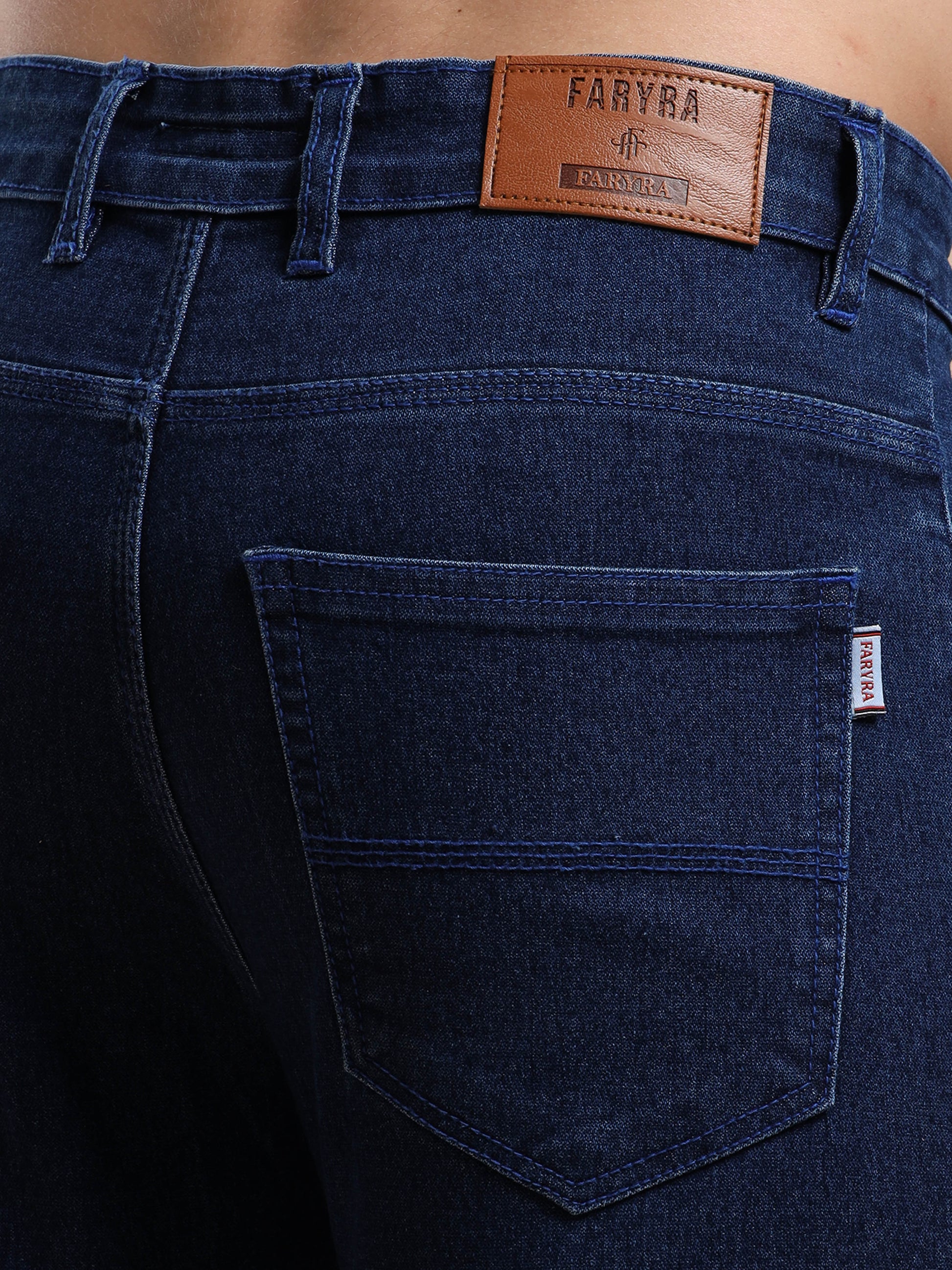 Back pocket with Faryra leather branding on men’s slim fit dark blue jeans
