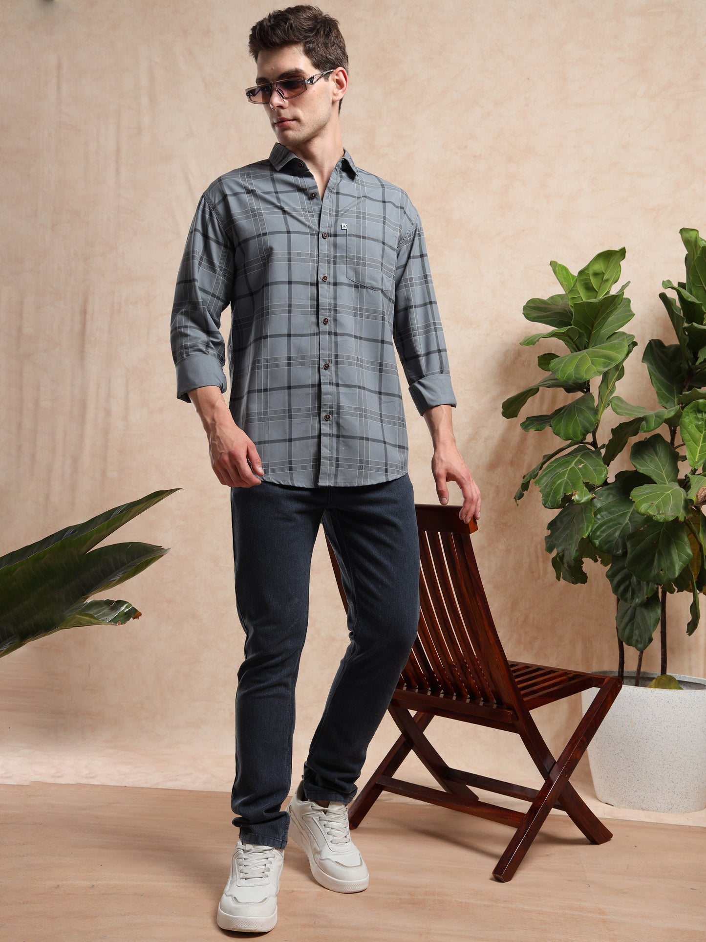 grey checked shirt with dark jeans and white sneakers.