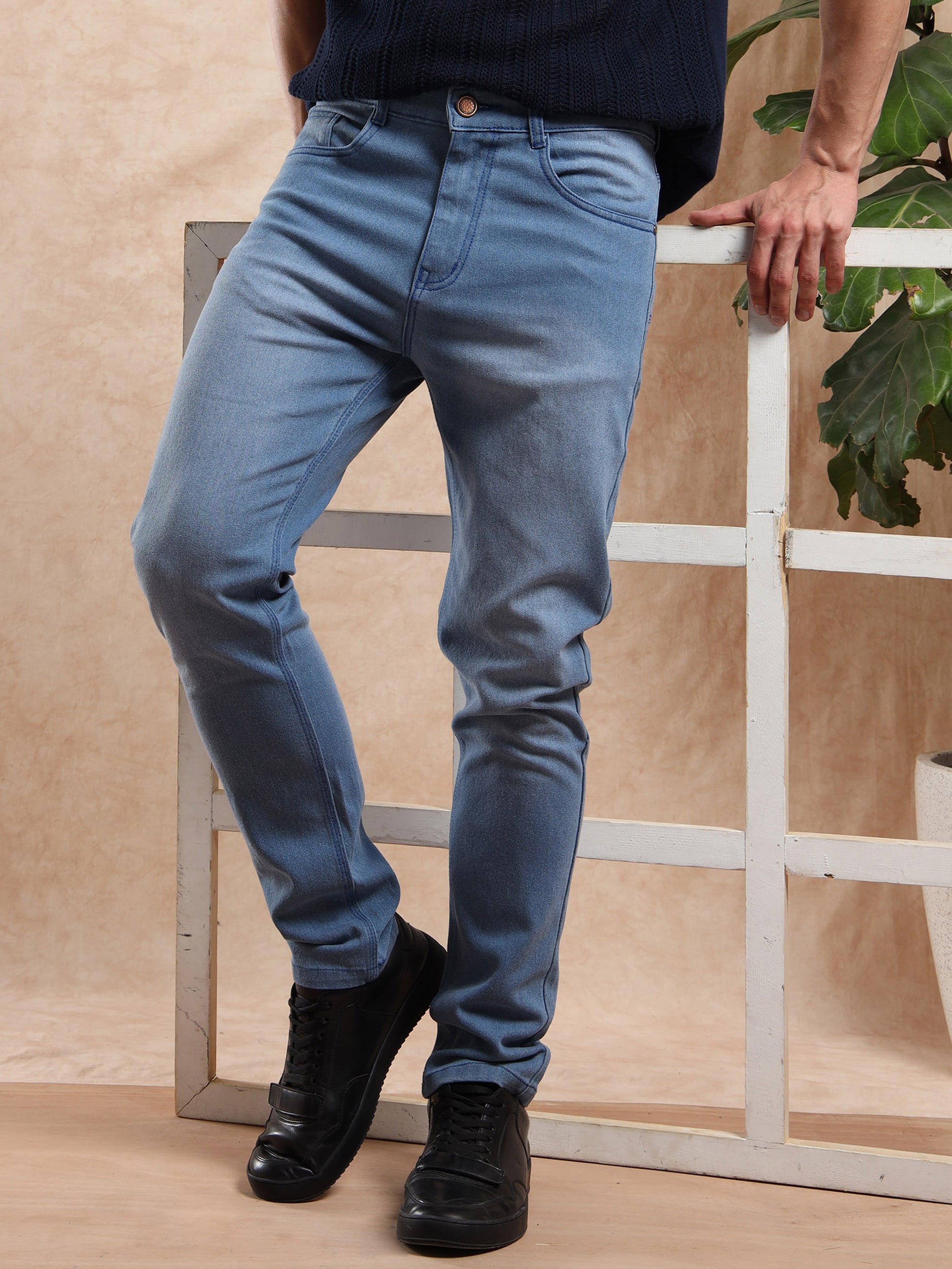 Model wearing slim fit blue jeans paired with black polo t-shirt and black sneakers.