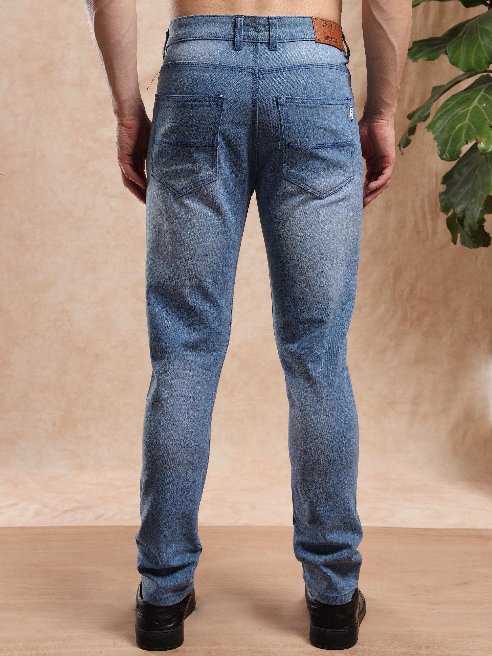 Men’s light wash jeans with back patch pockets and leather brand tag