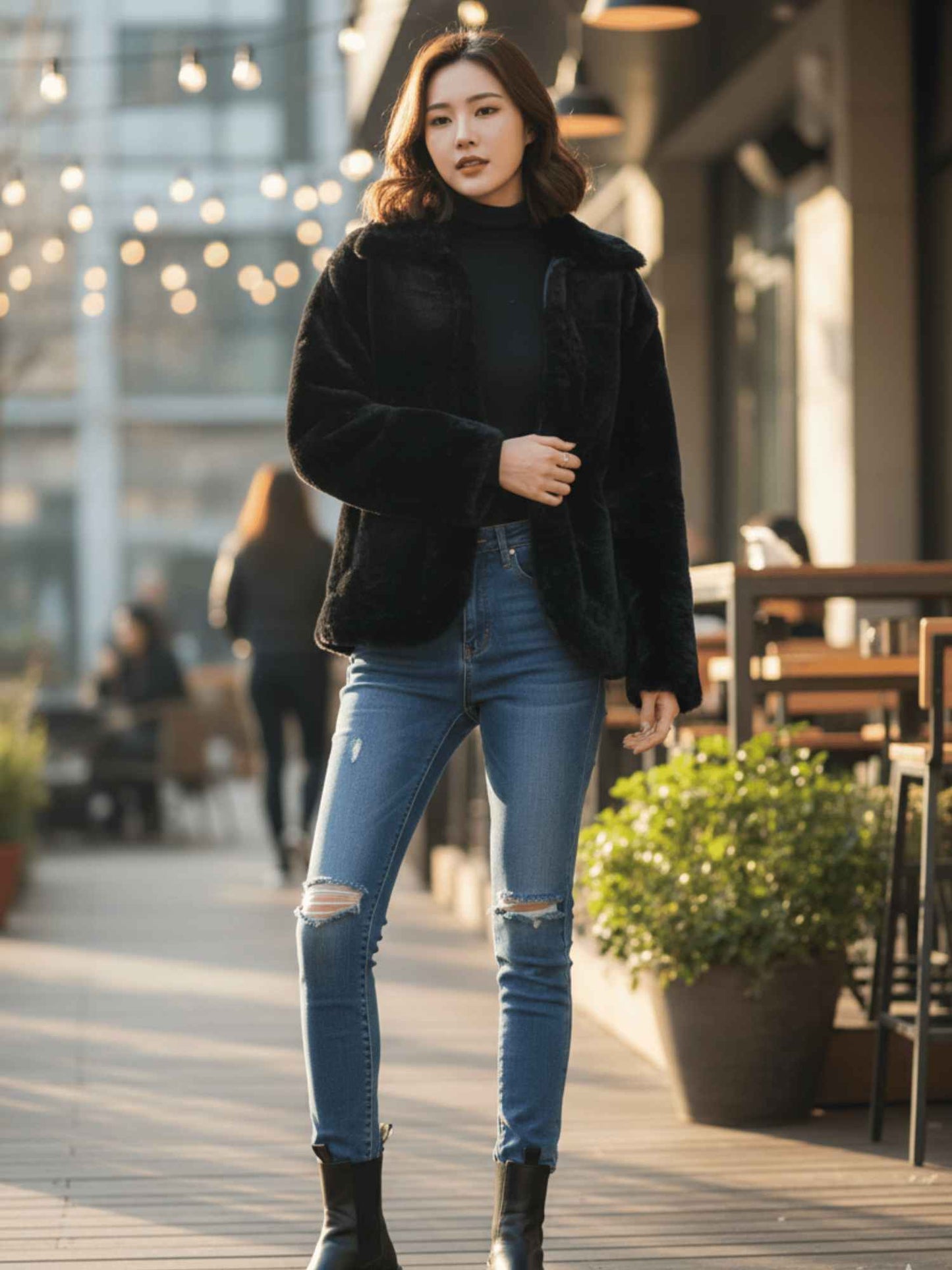 a black rabbit fur jacket, layered over a black turtleneck and distressed blue jeans,