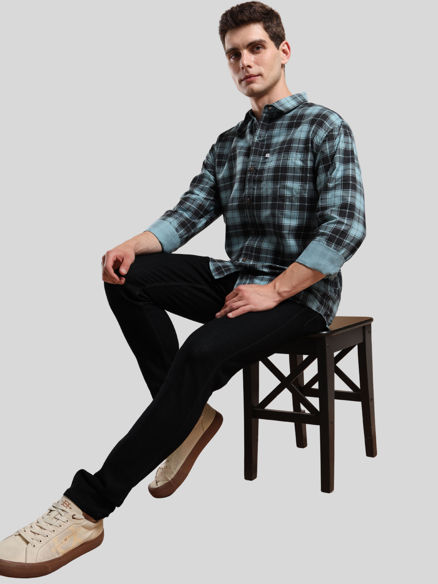 aqua blue checked shirt paired with black jeans and sneakers