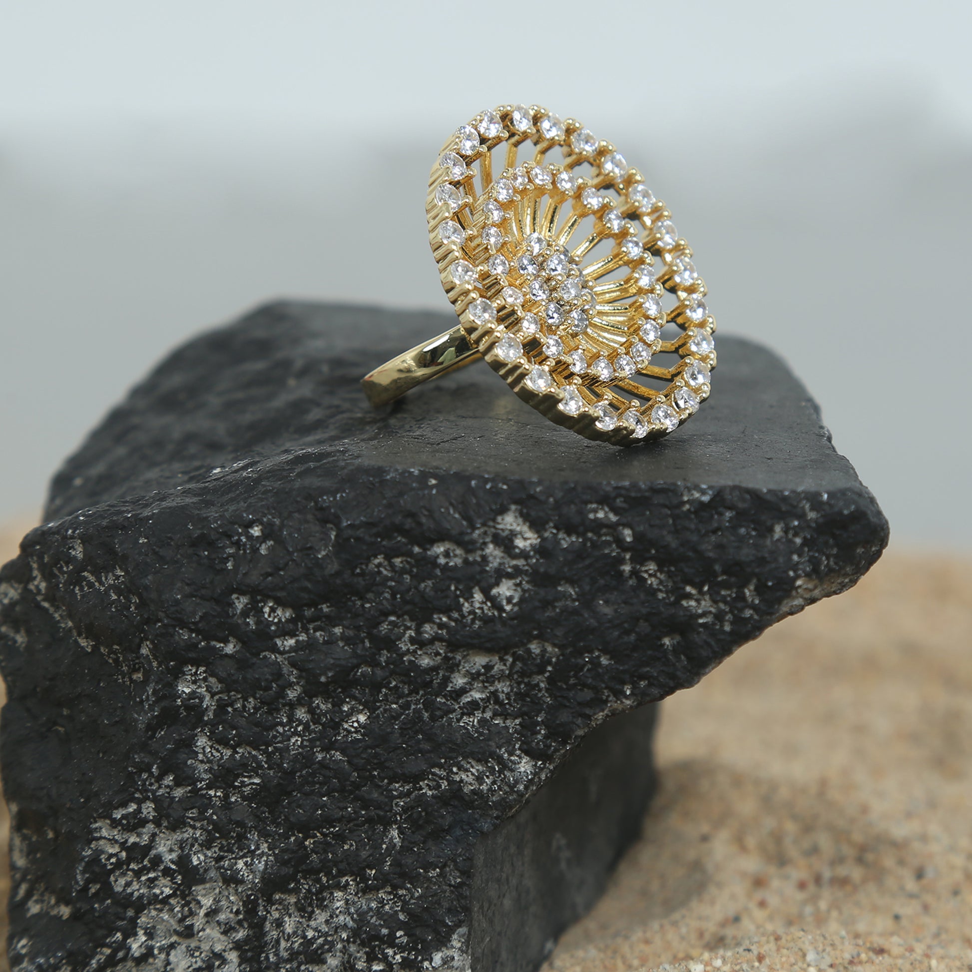 Gold-plated zirconic stone statement ring with intricate circular design.