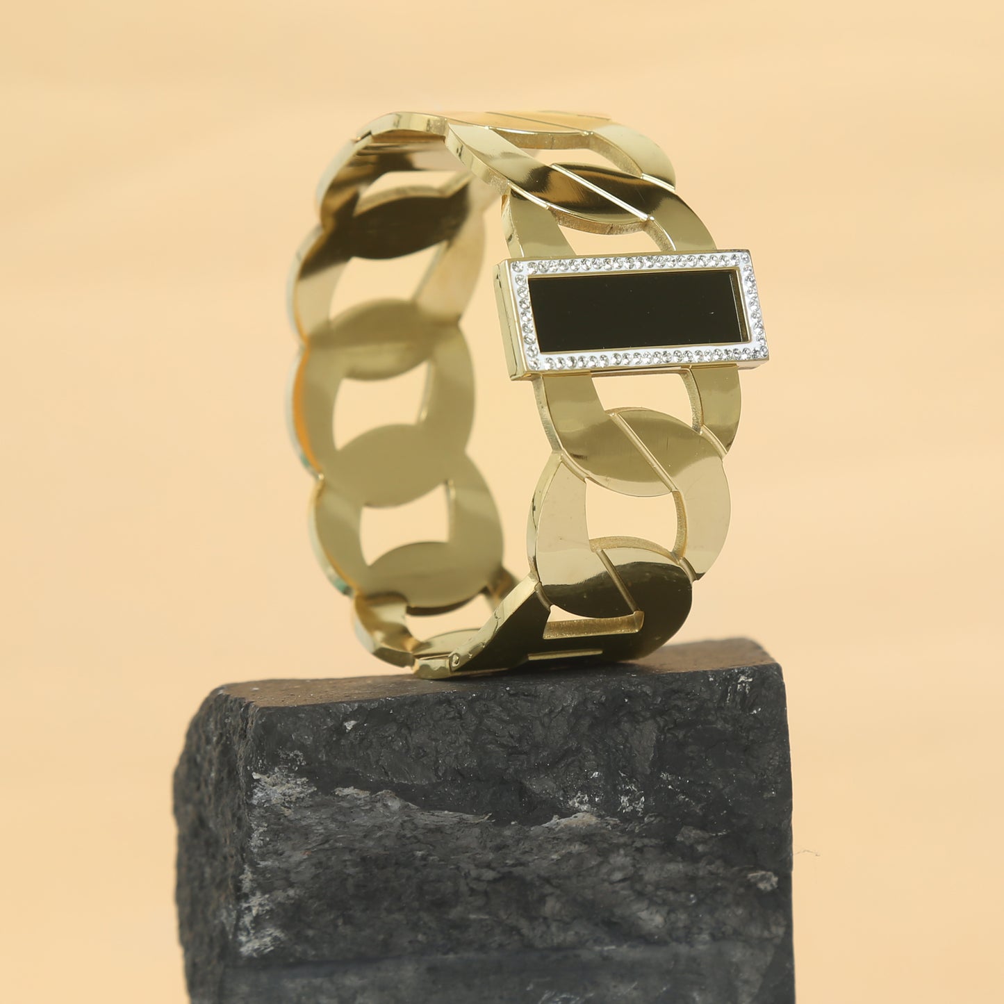 Luxurious gold chain bracelet featuring a sleek black onyx stone bordered with sparkling cubic zirconia