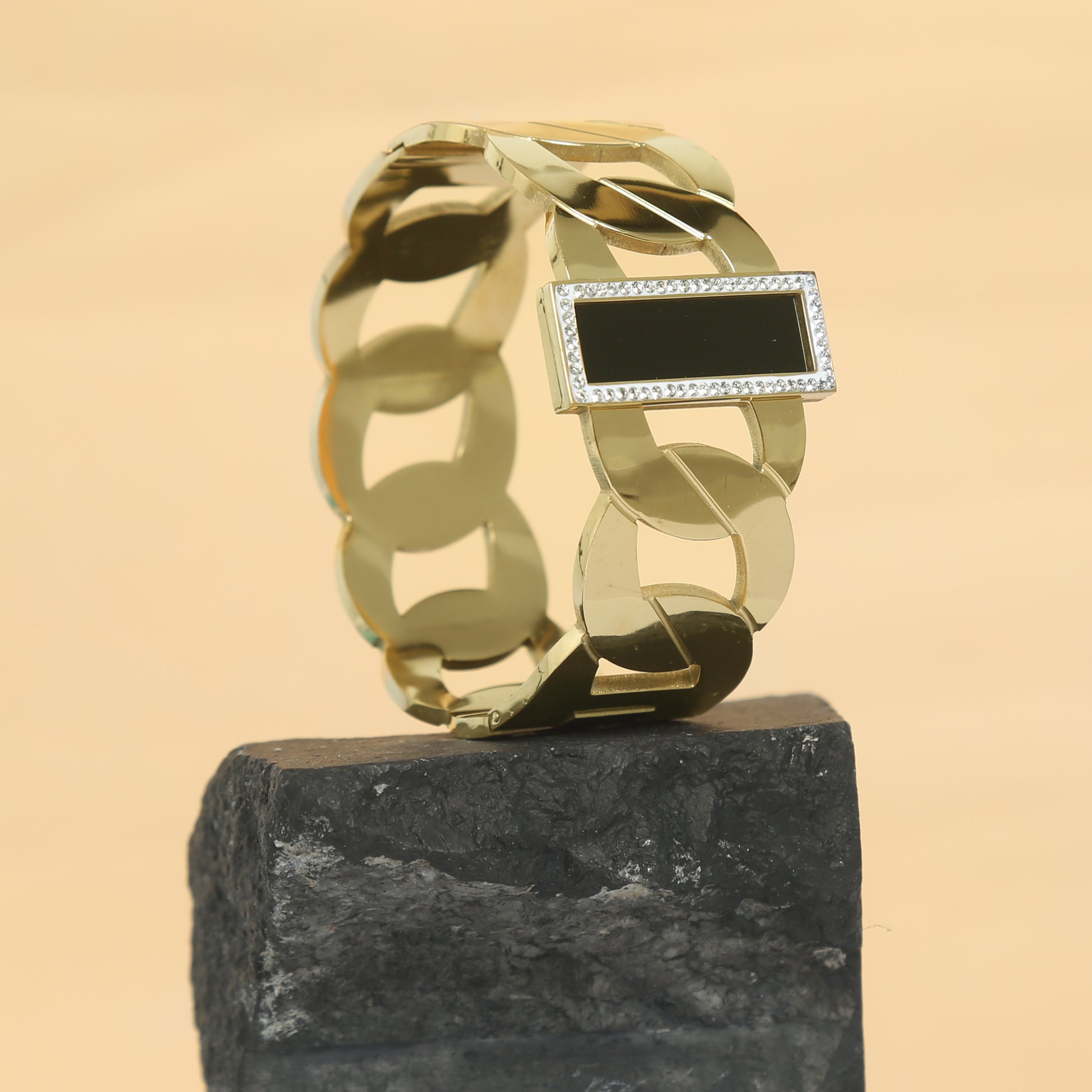 Luxurious gold chain bracelet featuring a sleek black onyx stone bordered with sparkling cubic zirconia