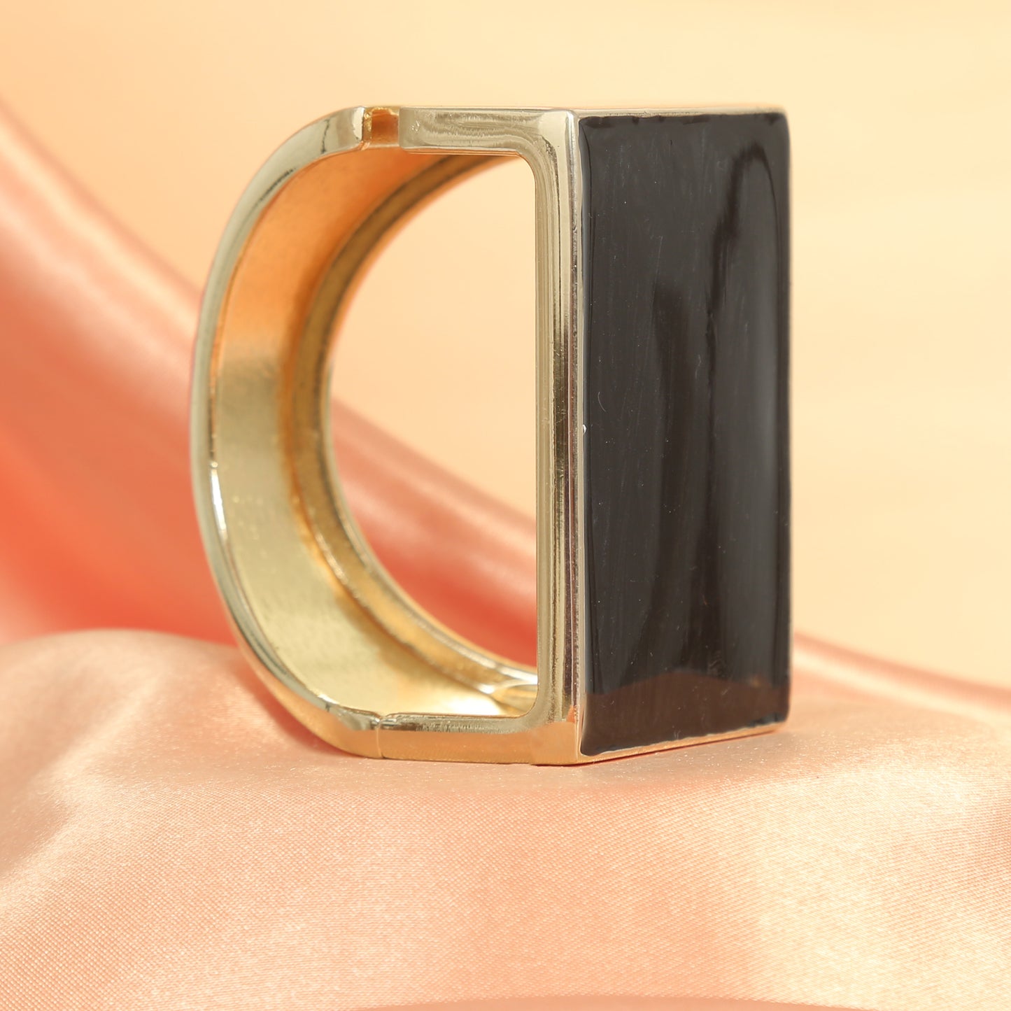 Elegant gold-plated rectangular bracelet with a glossy black onyx stone