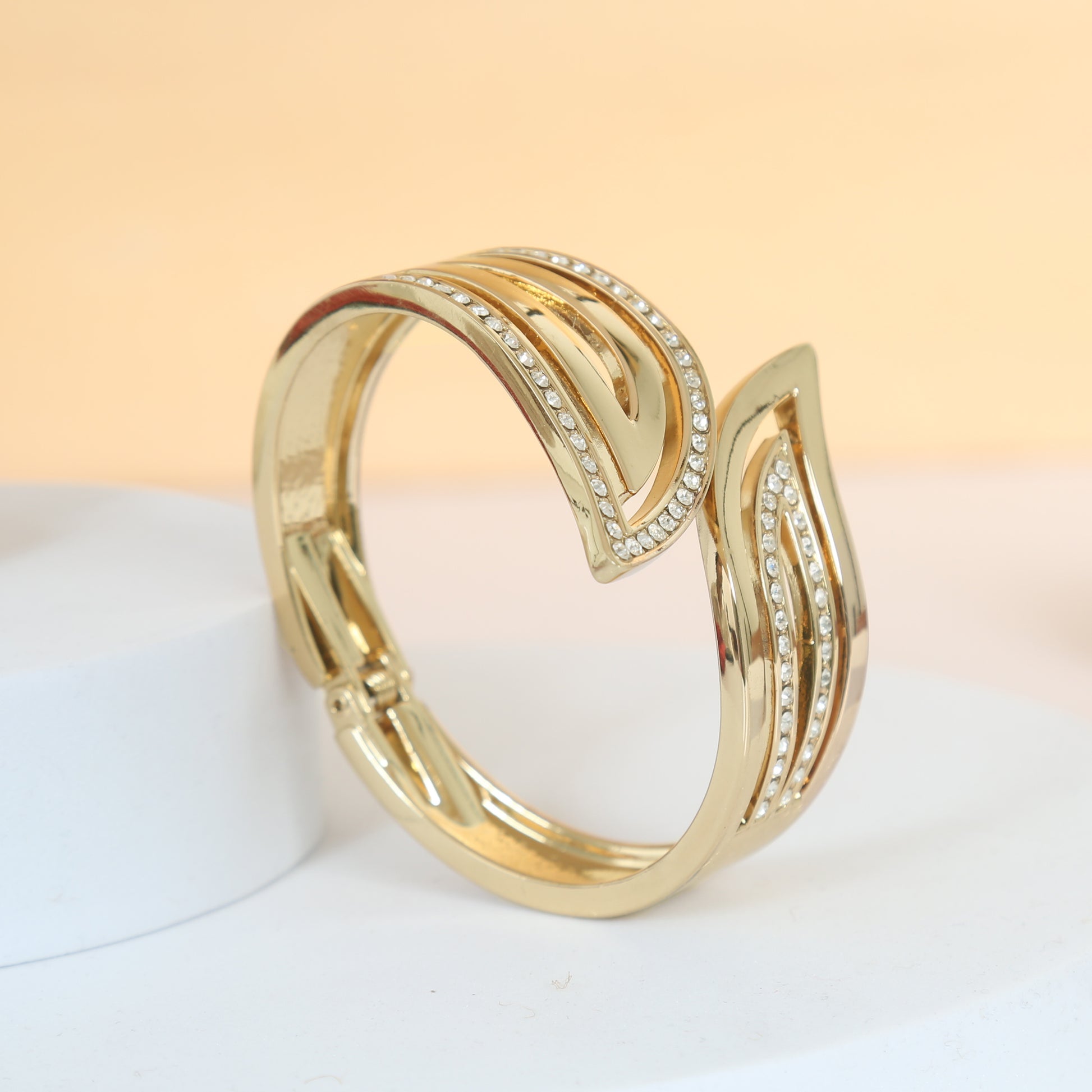 Stylish gold-plated bracelet with an elegant leaf-shaped open design, accented with rows of sparkling cubic zirconia stones