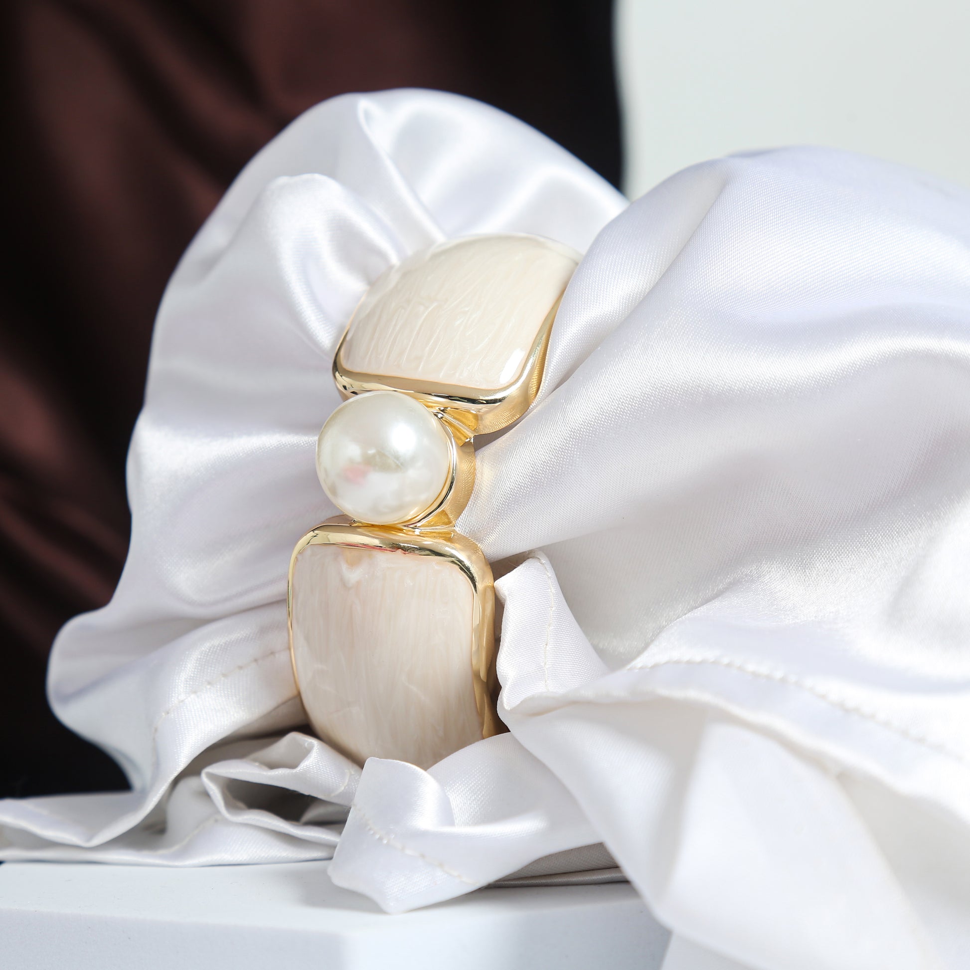 Elegant gold-plated bracelet with rectangular cream enamel accents and a central pearl