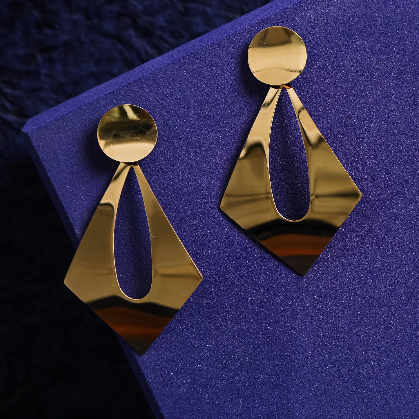 geometric gold-tone drop earrings with a circular stud and diamond-shaped open design