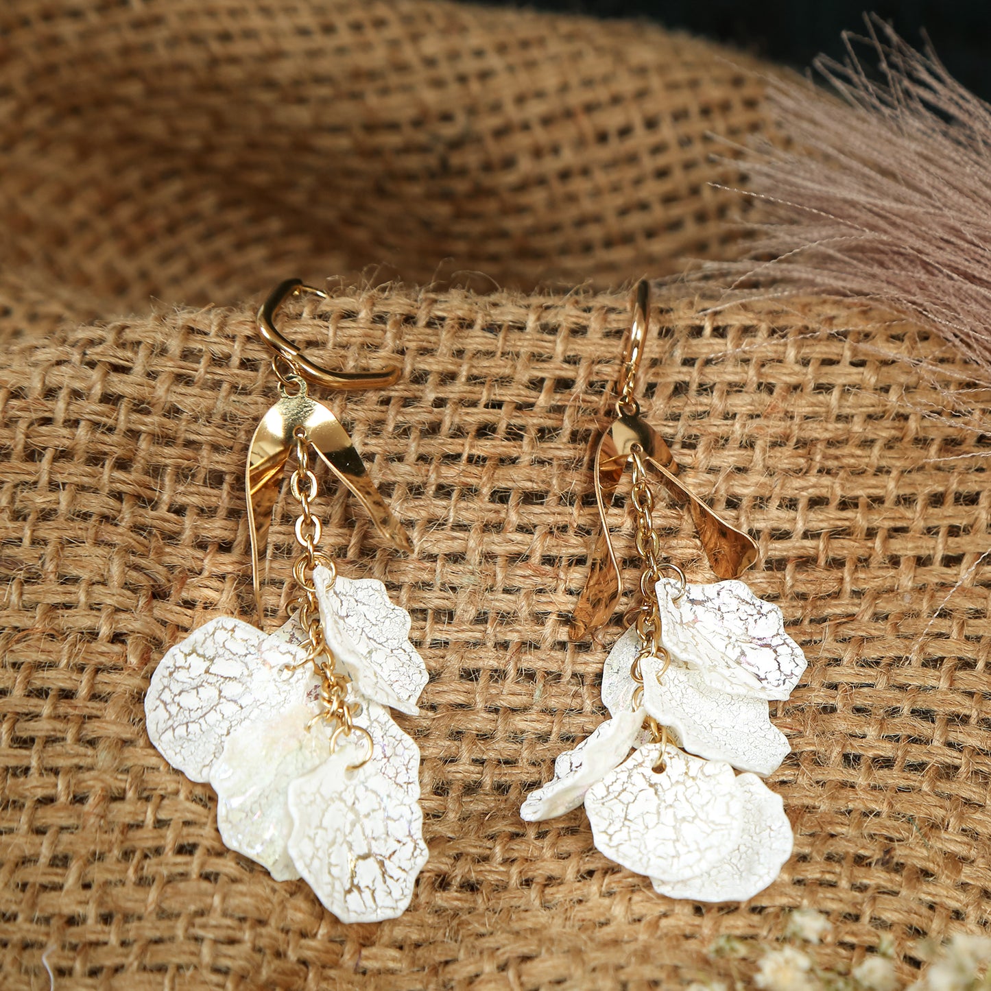 Gold floral drop earrings with delicate white petal-shaped charms
