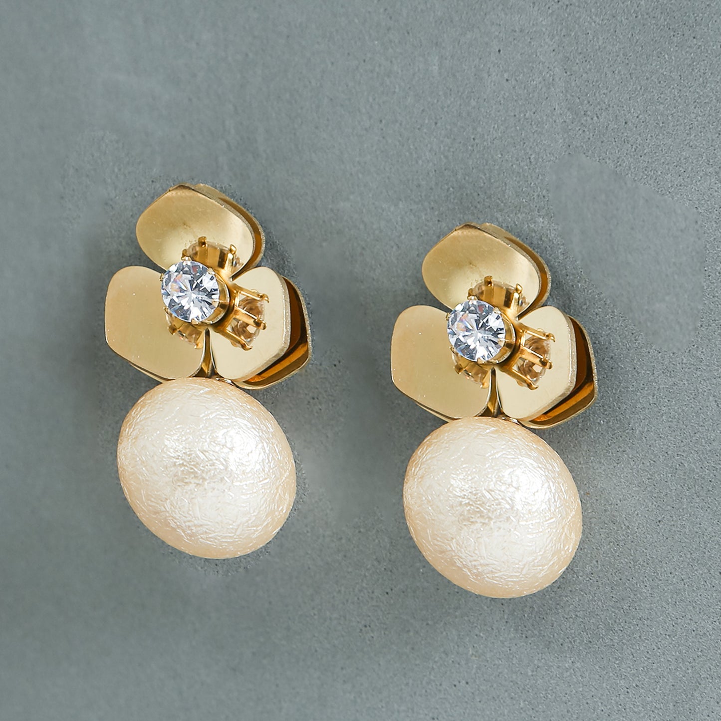 Gold floral stud earrings with crystal center and textured pearl drop