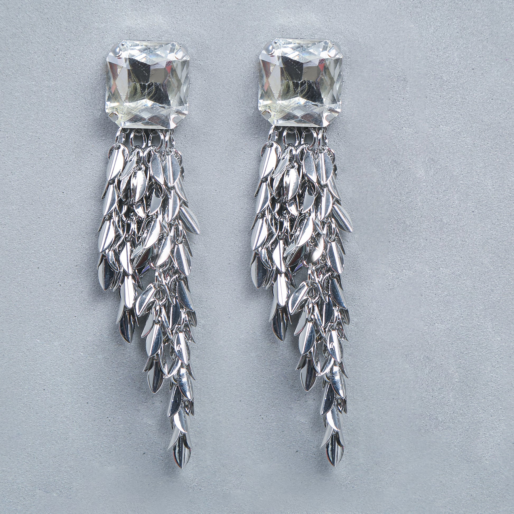 Silver statement drop earrings with large crystal stud and cascading metallic tassel design