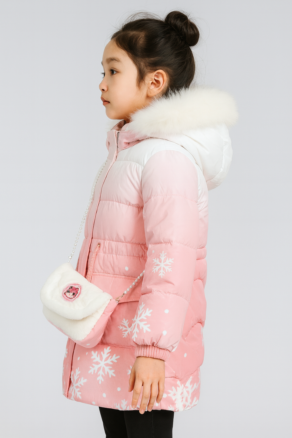 Side view of a pink winter coat with white snowflake patterns, a white-to-pink gradient hood trimmed with white faux fur, and carrying a small white faux fur purse with a cartoon character patch.