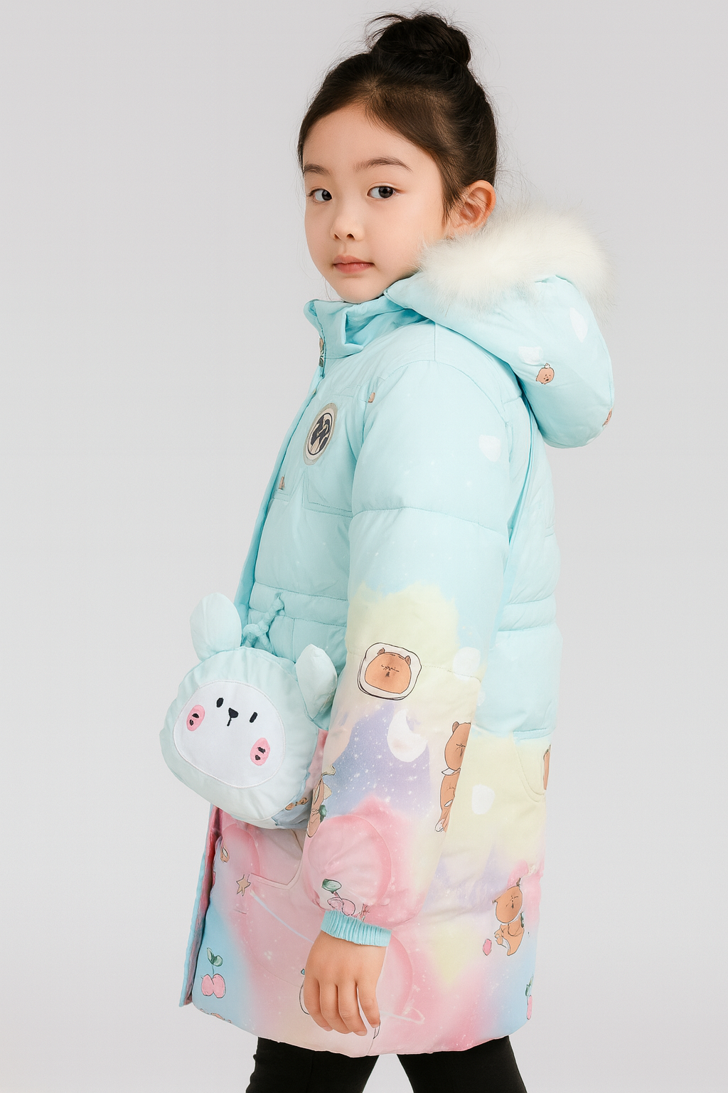 a light blue winter coat with pastel rainbow gradient, cartoon bear and cherry prints, and a white faux fur-trimmed hood, accessorized with a small light blue crossbody bag shaped like a cute bunny face.