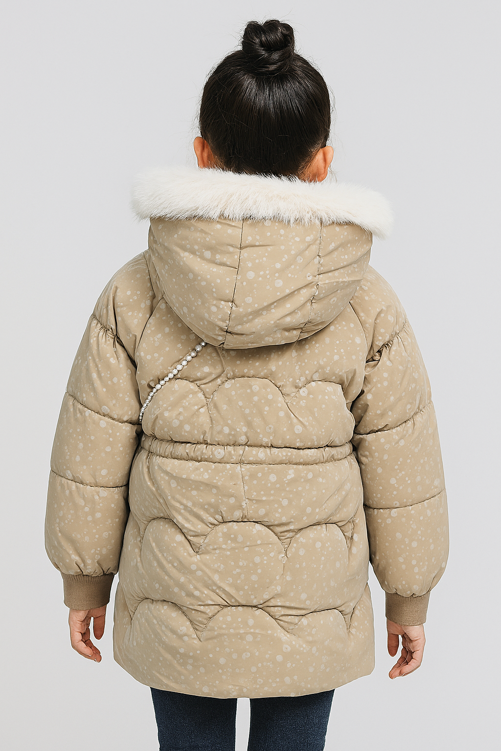 Back view of  a beige puffer jacket with subtle white polka dots, a white faux fur-lined hood, and a pearl strap from a crossbody bag
