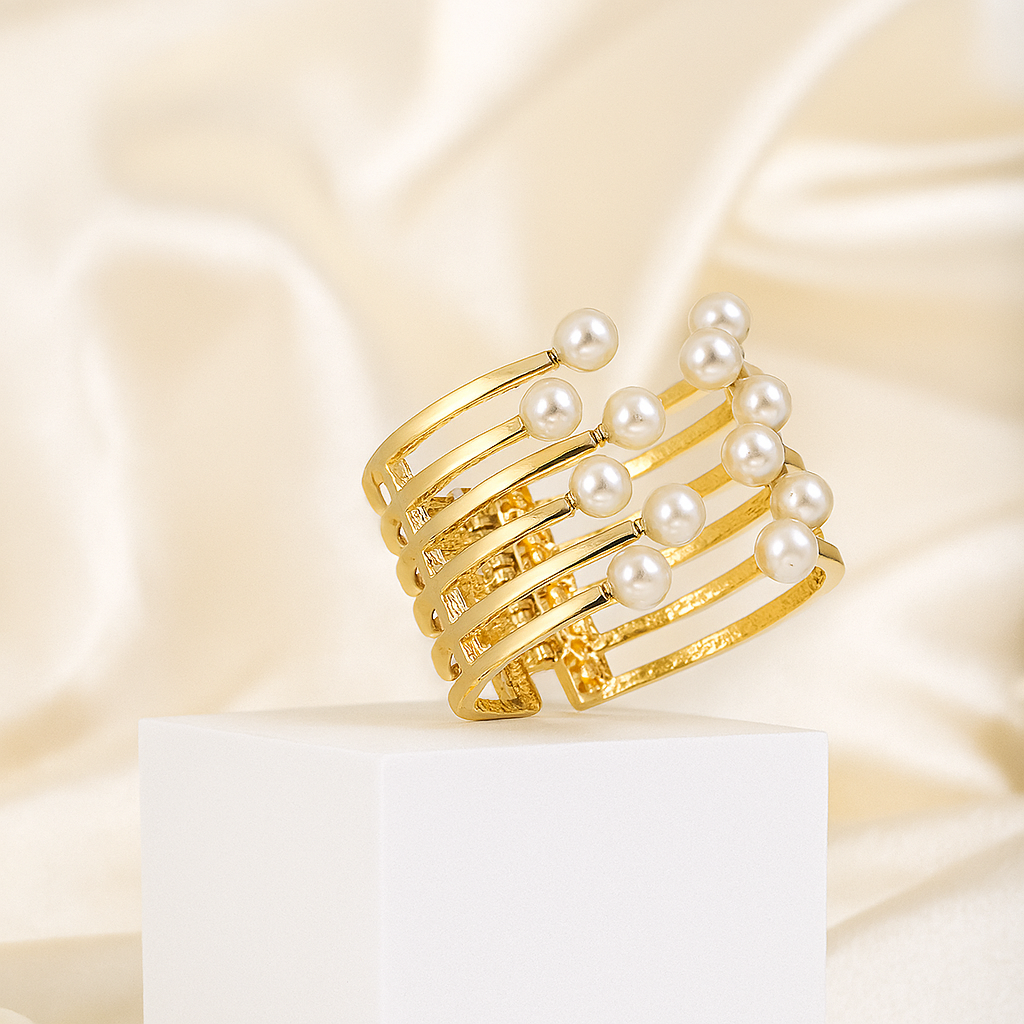 Luxurious gold layered cuff bracelet featuring evenly spaced imitation pearls