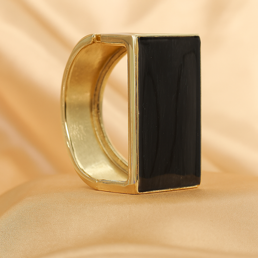 Bold statement bracelet featuring a rectangular black onyx stone set in gold plating