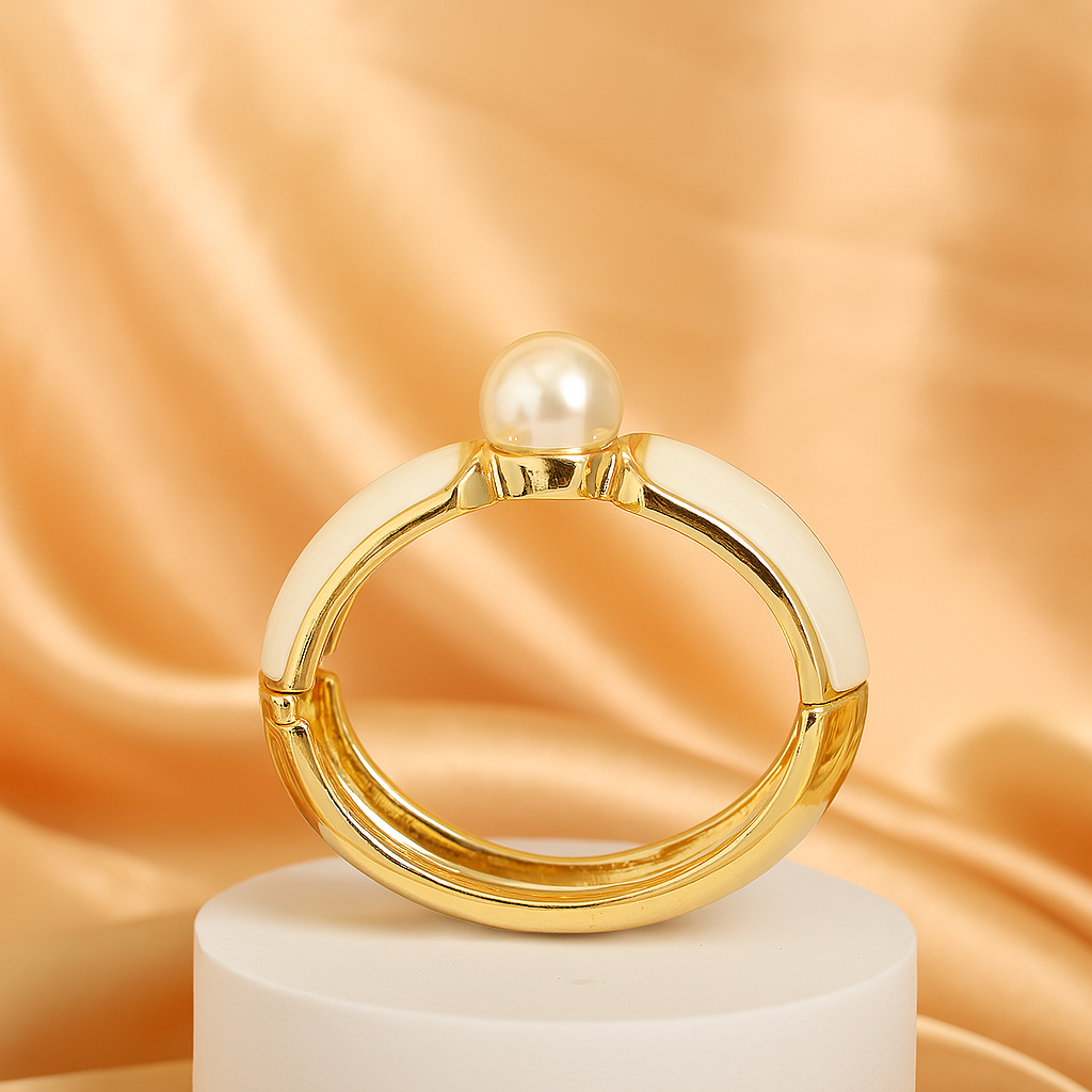 Luxurious gold-plated bangle bracelet with white enamel finish and a single pearl centerpiece