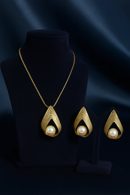 Elegant gold-plated necklace and earring set with teardrop-shaped design, featuring a large pearl centerpiece