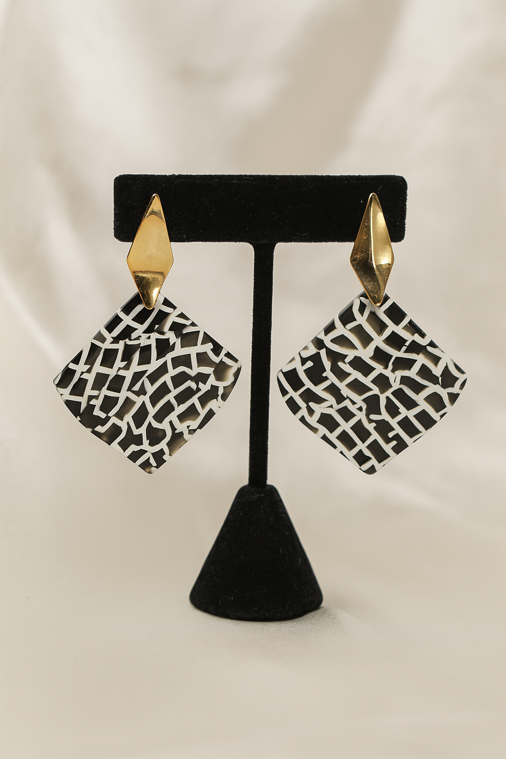 Geometric black and white resin drop earrings with gold diamond-shaped stud
