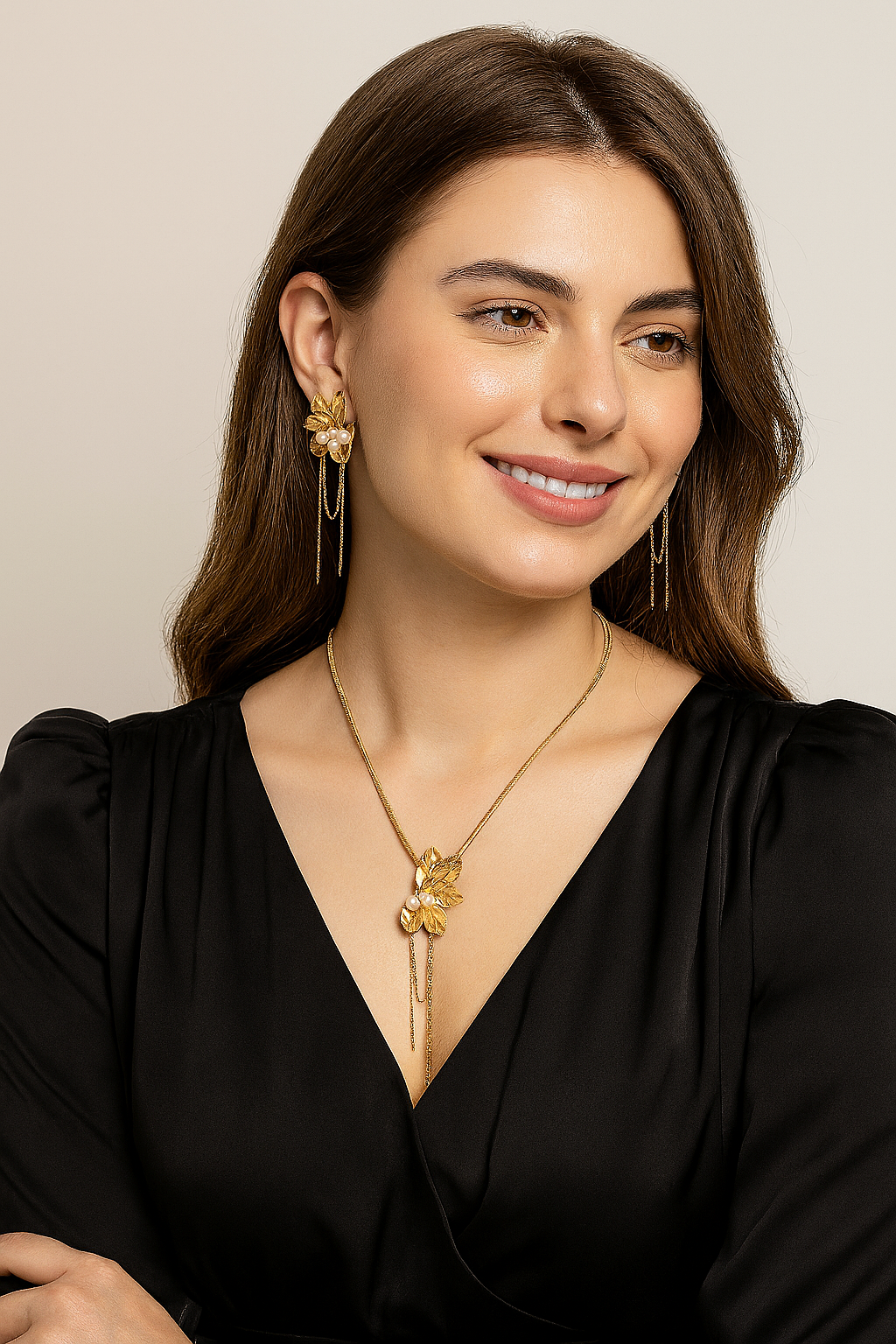 Woman wearing a gold plated floral necklace and matching pearl drop earrings with chain tassels