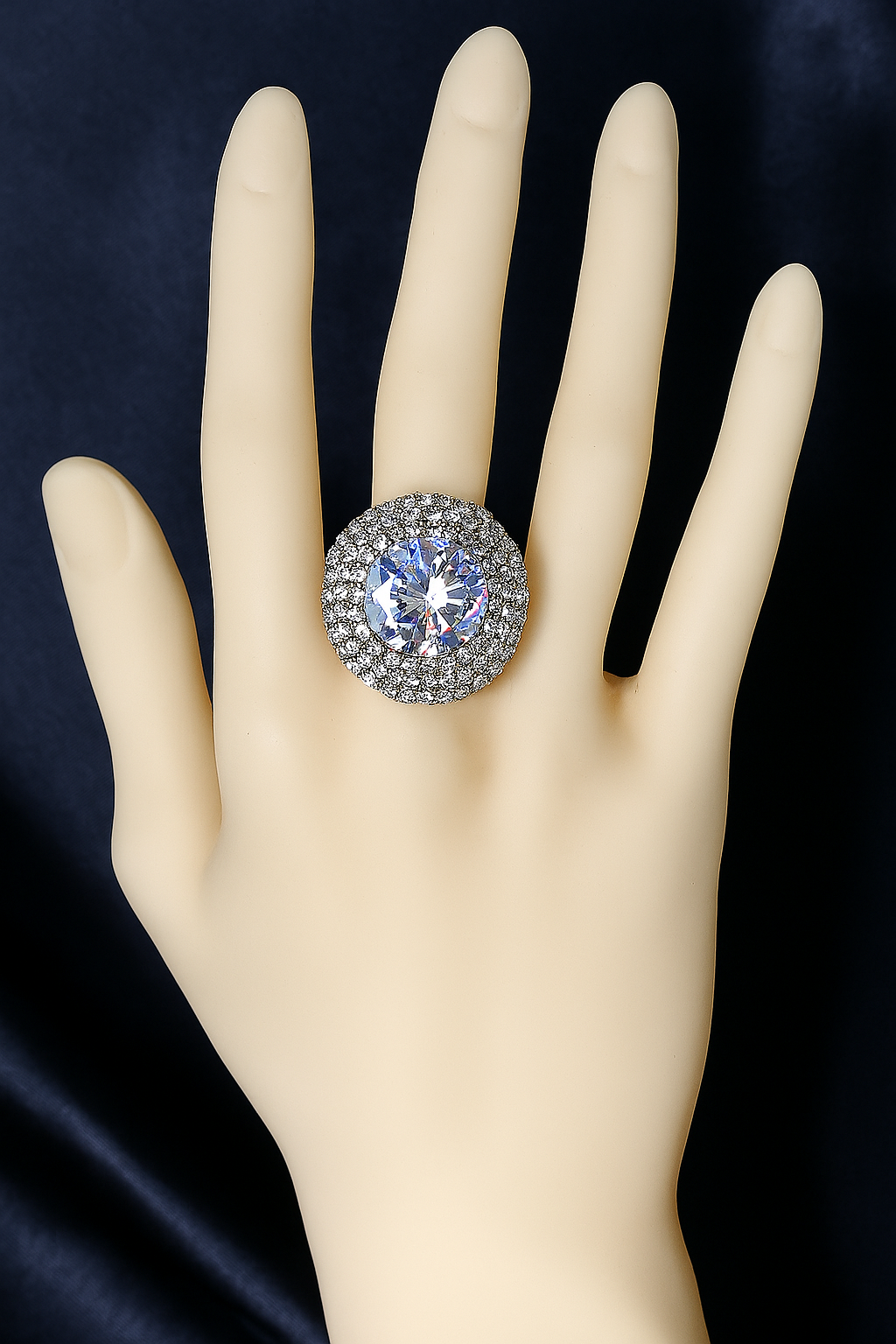 Elegant zirconic stone ring with a large round centerpiece and halo of crystals displayed on a mannequin