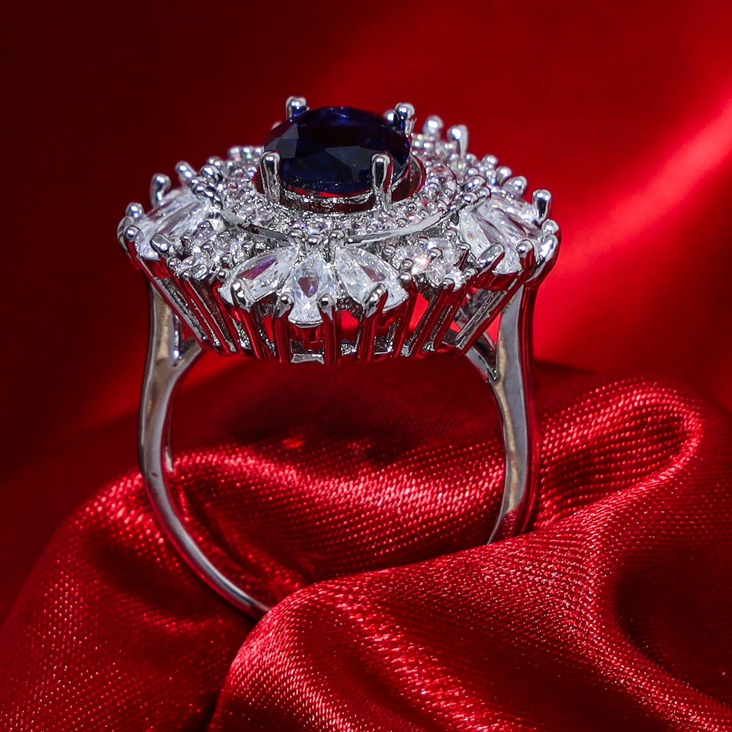 Side profile view of an oval blue zirconic stone ring with intricate diamond halo setting