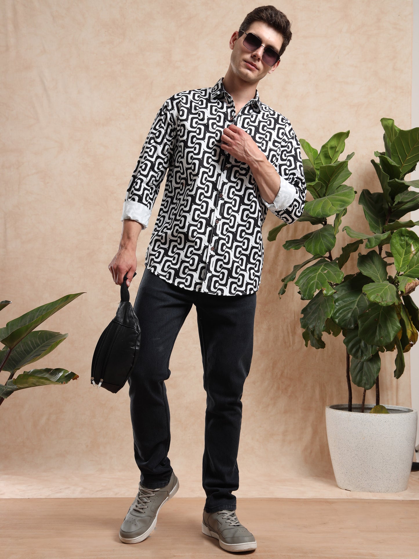 Men, casual outfit with black and white printed shirt styled with black jeans and grey sneakers