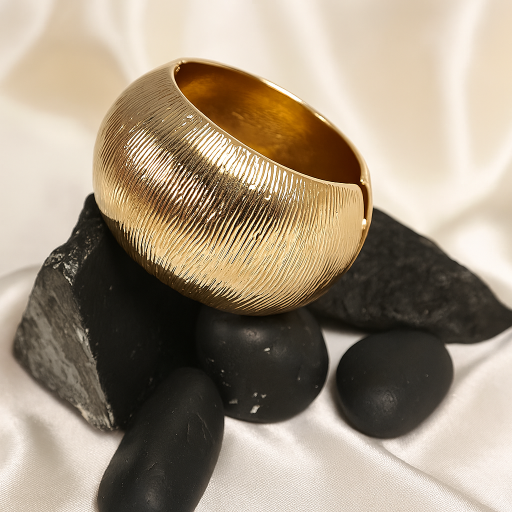 Gold textured bowl on black stones with a white background
