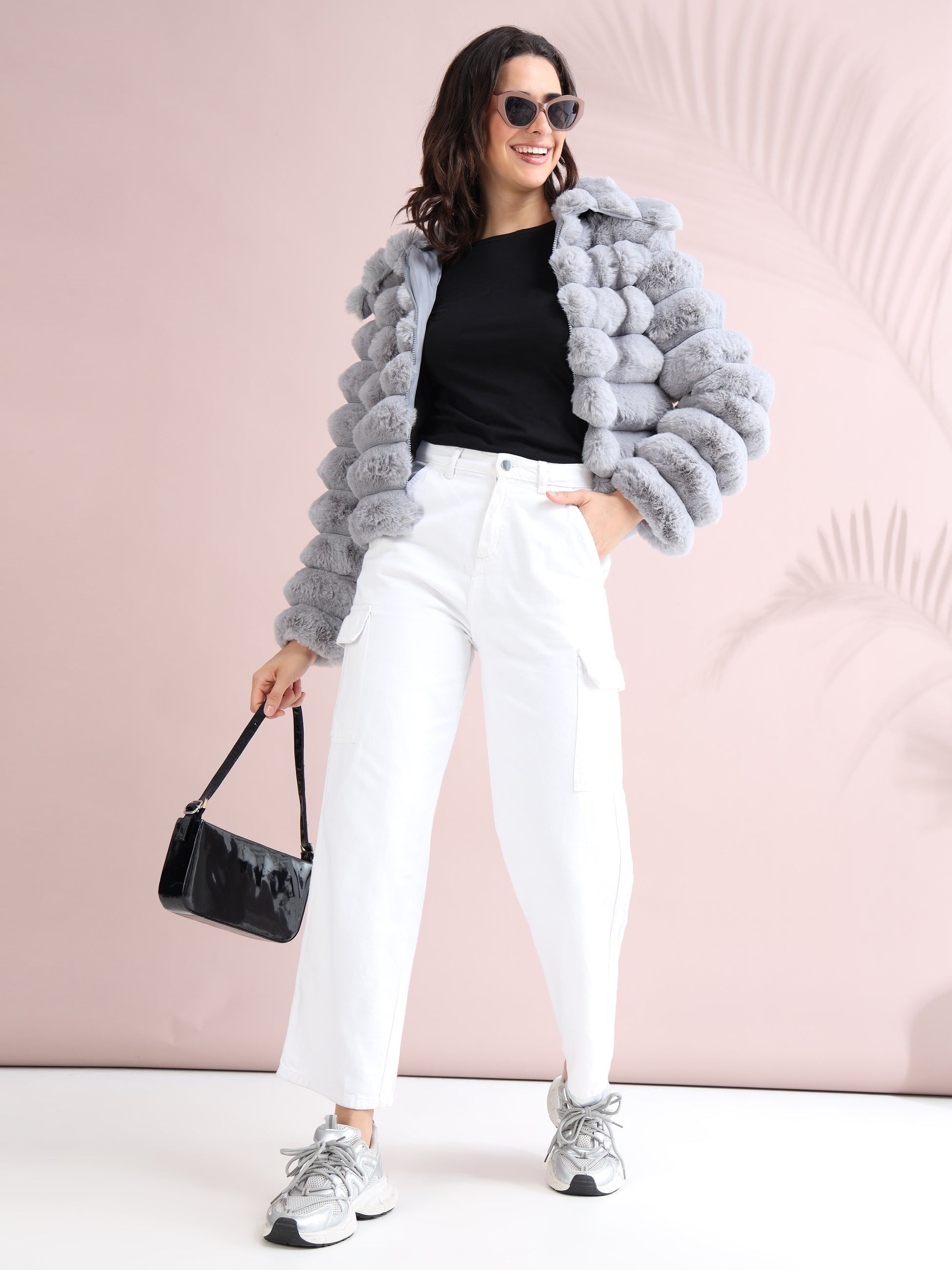 grey faux fur jacket with black top, white wide-leg pants, sneakers, sunglasses, and a black handbag.