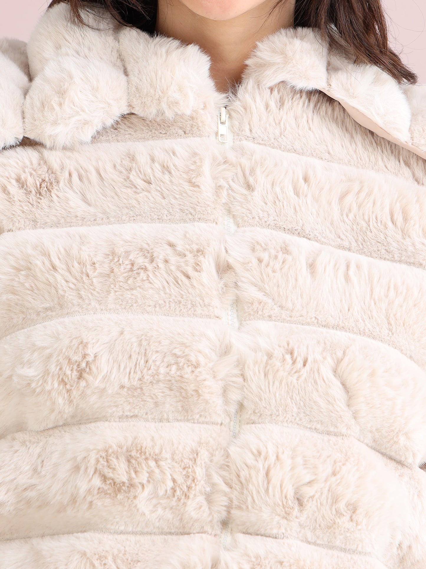 beige faux fur jacket showing soft plush texture and zip fastening detail
