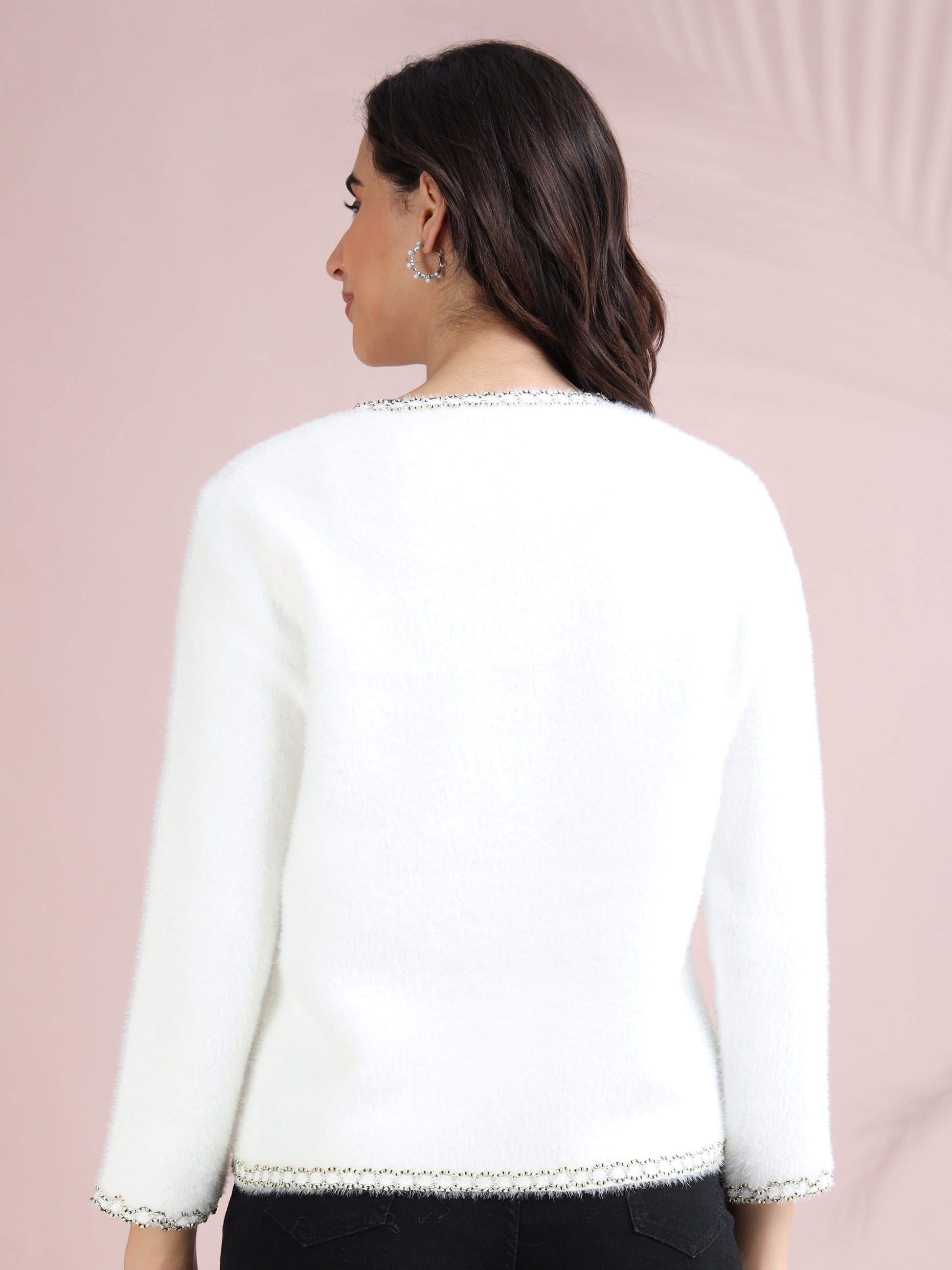 Back view of white pearl button cardigan showcasing clean design and textured fabric.